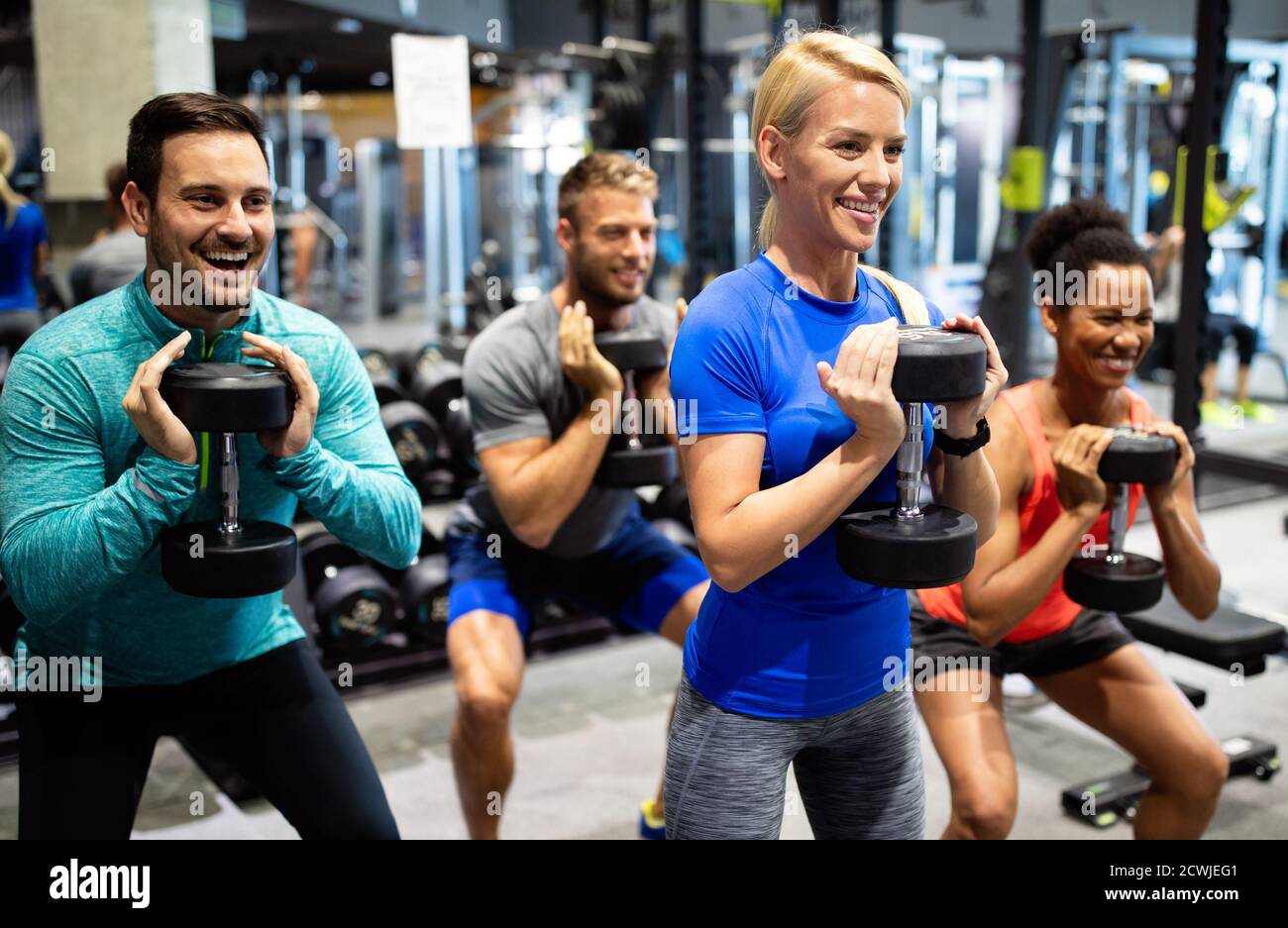 Group of fit people in gym training. Multiracial group of friends working out together Stock Photo