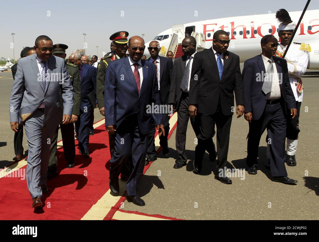 Sudanese President Omar Hassan al-Bashir (C) welcomes Ethiopian Prime Minister Hailemariam Desalegn (L) at Khartoum Airport, ahead of their signing of an Agreement on Declaration of Principles between Sudan, Egypt and Ethiopia on the Grand Ethiopian Renaissance Dam Project,  in Khartoum March 23, 2015. The leaders of Egypt, Ethiopia and Sudan signed a cooperation deal on Monday over a giant Ethiopian hydroelectric dam on a tributary of the river Nile, in a bid to ease tensions over regional water supplies. The leaders said the 'declaration of principles' would pave the way for further diplomat Stock Photo
