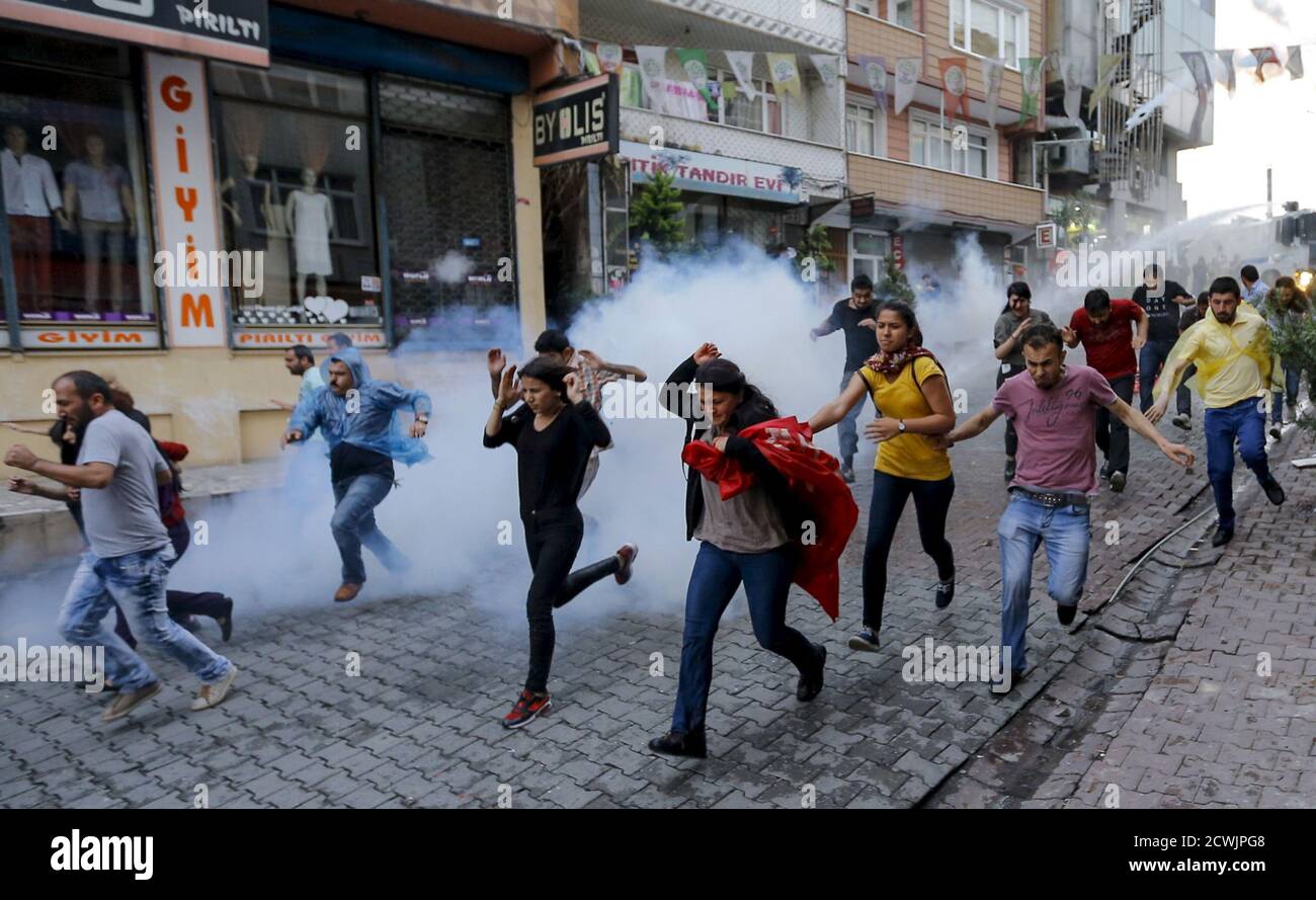Protesters run from water cannon and tear gas used by riot police to disperse them during a protest march to commemorate teenager Berkin Elvan, in Istanbul, Turkey, June 16, 2015. Riot police fired water cannons to disperse protesters in Istanbul as they marched to mark the second anniversary of the date Elvan got injured, the 15-year-old boy who suffered a head injury during anti-government protests in Istanbul in June 2013, dying on March 11, 2014 after spending months in a coma. REUTERS/Huseyin Aldemir Stock Photo