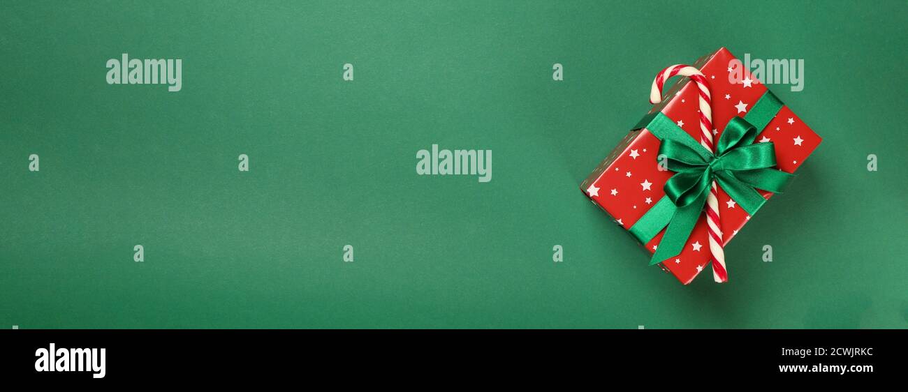 Christmas box with candy cane on green background Stock Photo - Alamy