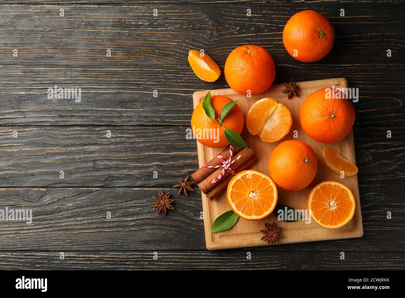 Board with mandarins and cinnamon on wooden background Stock Photo