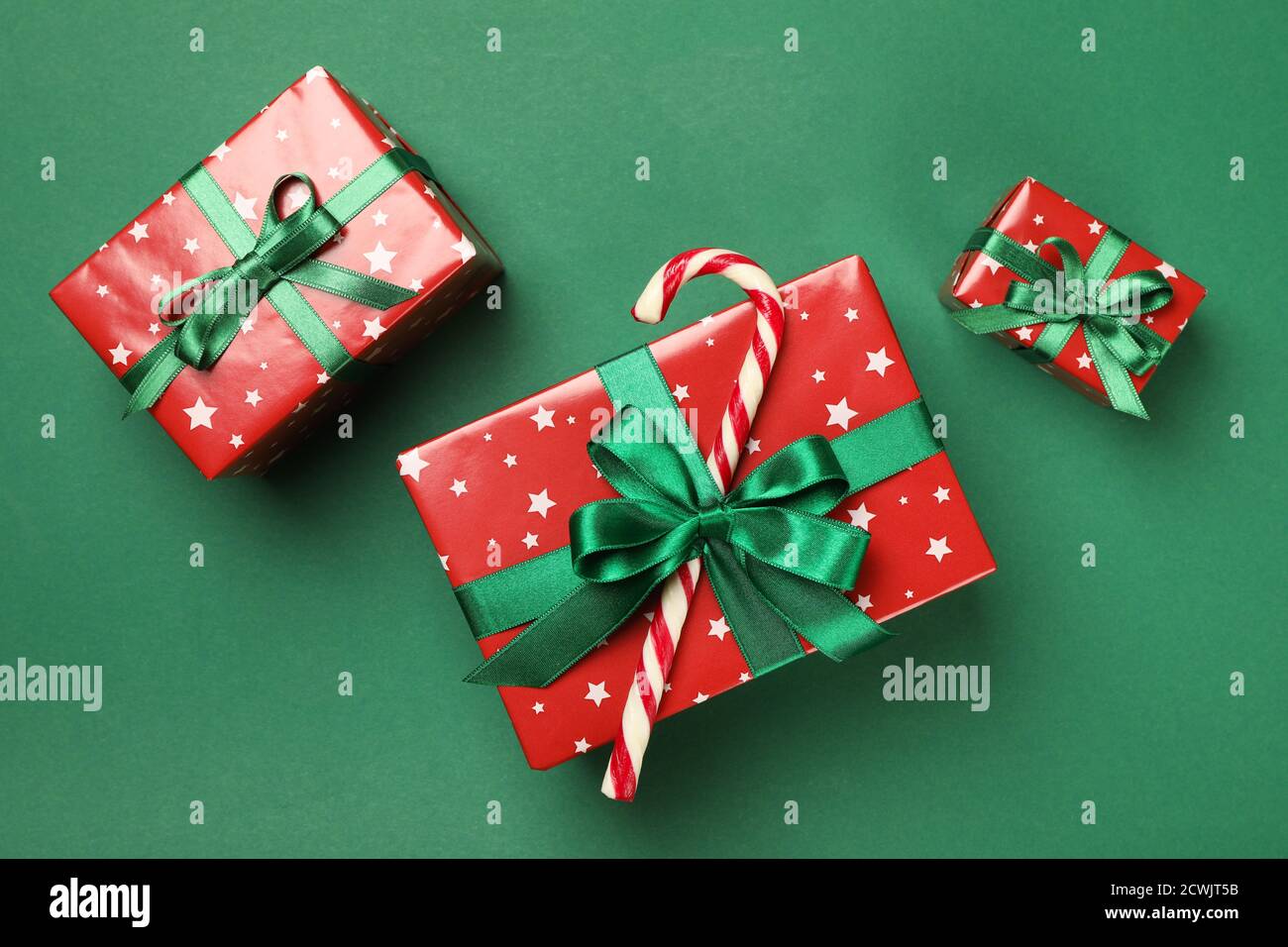 Christmas boxes and candy cane on green background Stock Photo - Alamy