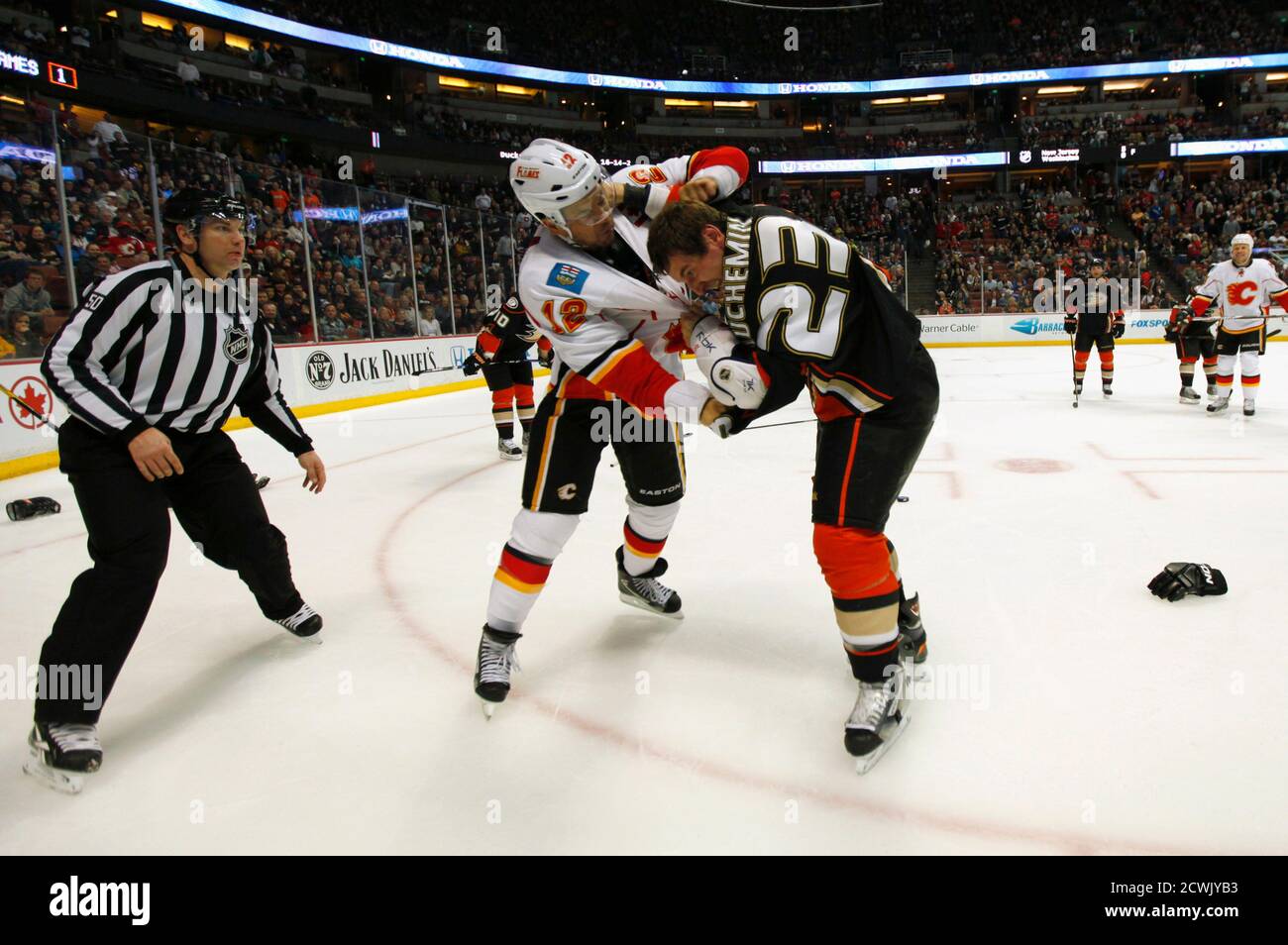 Linesman Steve Miller (L) watches as Calgary Flames right wing Jarome Iginla (12) fights Anaheim Ducks defenseman Francois Beauchemin (23) during their NHL hockey game in Anaheim, California March 2, 2012.  REUTERS/ Mike Blake (UNITED STATES - Tags: SPORT ICE HOCKEY TPX IMAGES OF THE DAY) Stock Photo