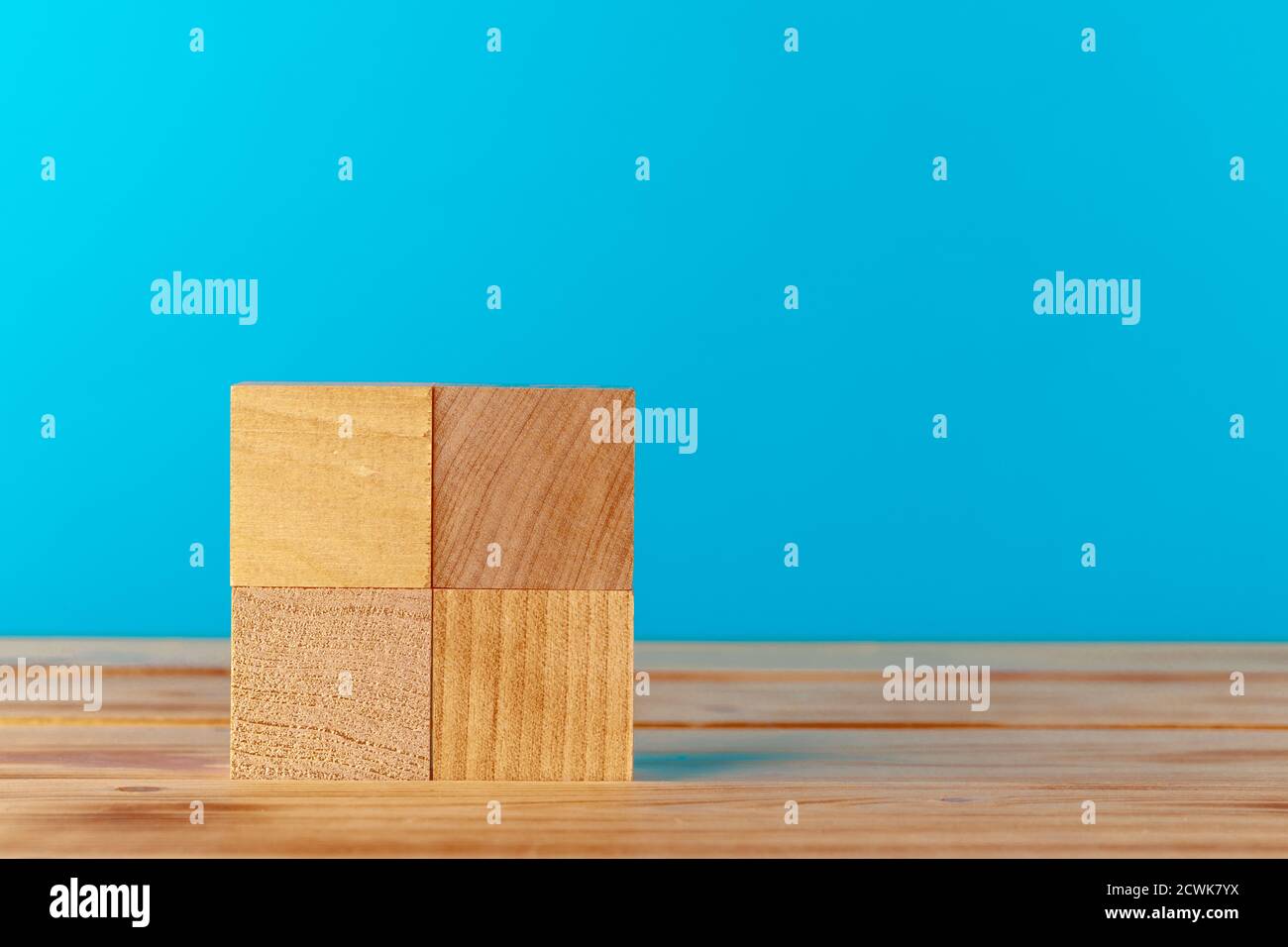 Stacked wooden blocks on wooden desk against blue background Stock ...
