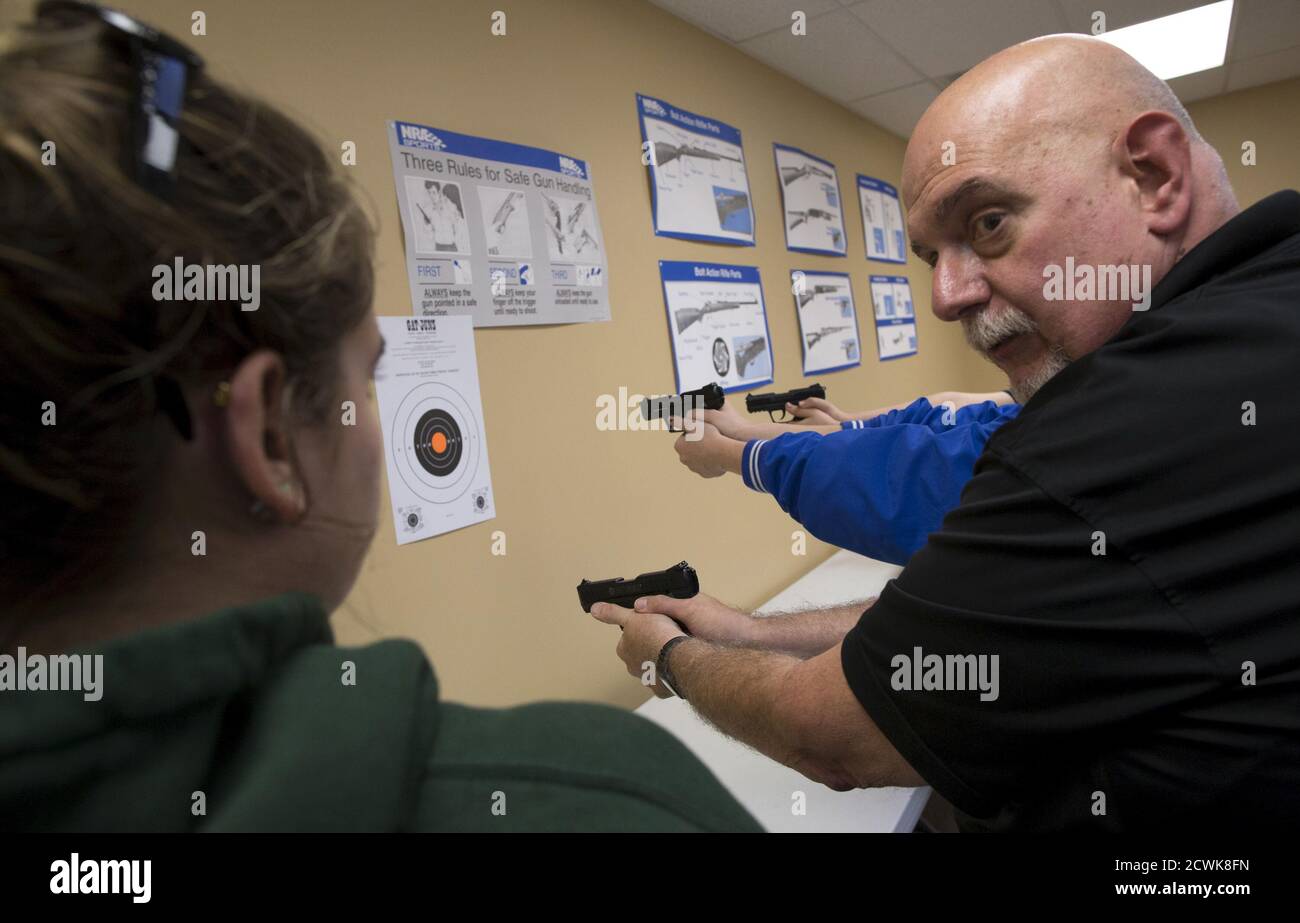 Instructor Wayne Inzerello (R) demonstrates how to hold a handgun to Savannah  Garner during a Youth Handgun Safety Class at GAT Guns in East Dundee,  Illinois, April 21, 2015. The class is