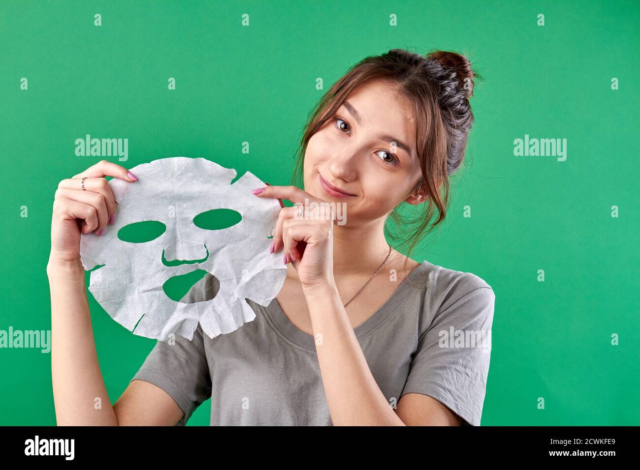 Portrait of young woman holding spa sheet mask. Stock Photo