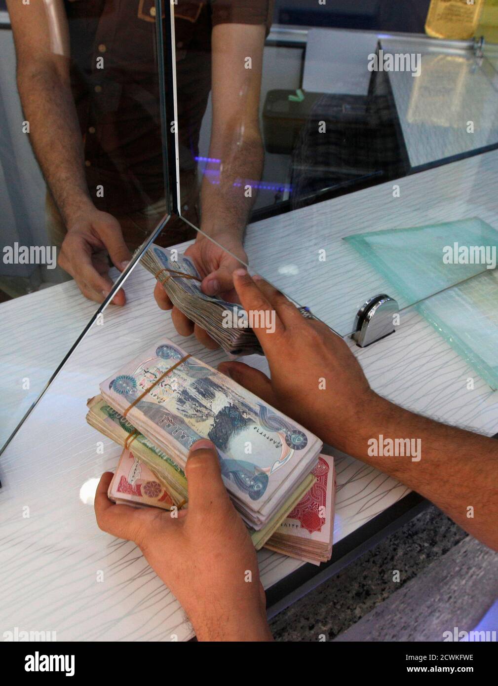 A customer changes U.S. dollars to Iraqi dinars at a money changer in Baghdad October 1, 2012. Many Iraqis have lost faith in their dinar currency but to some foreign speculators, it