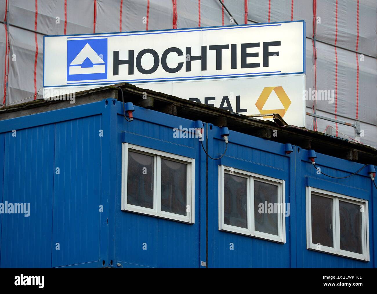 The Logo Of German Construction Company Hochtief Is Seen Behind A Container At The Construction Site For Elbphilharmonie Philharmonic Hall In Downtown Hamburg February 26 2013 German Builder Hochtief Swung To A
