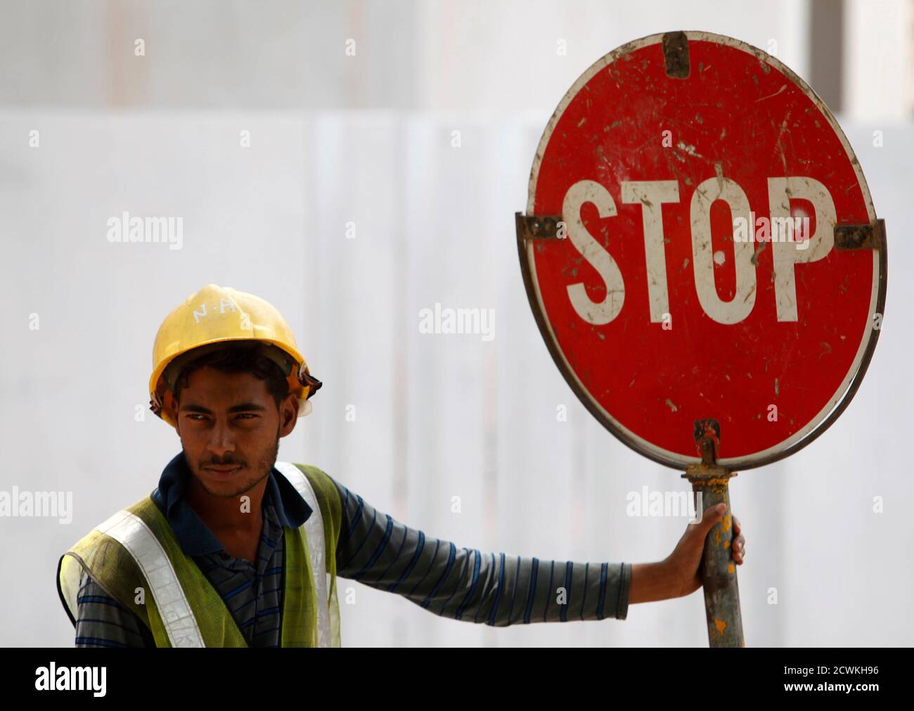 A foreign worker directs traffic along a busy construction site in Singapore, March 12, 2013. REUTERS/Edgar Su (SINGAPORE - Tags: BUSINESS EMPLOYMENT CONSTRUCTION SOCIETY) Stock Photo