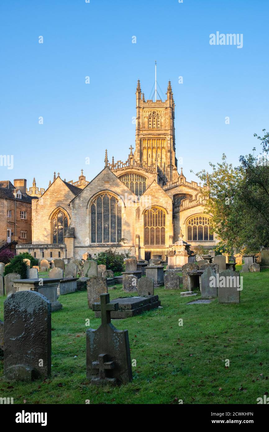 The Church of St. John the Baptist from the garden of rememberance at sunrise in autumn. Cirencester, Cotswolds, Gloucestershire, England Stock Photo