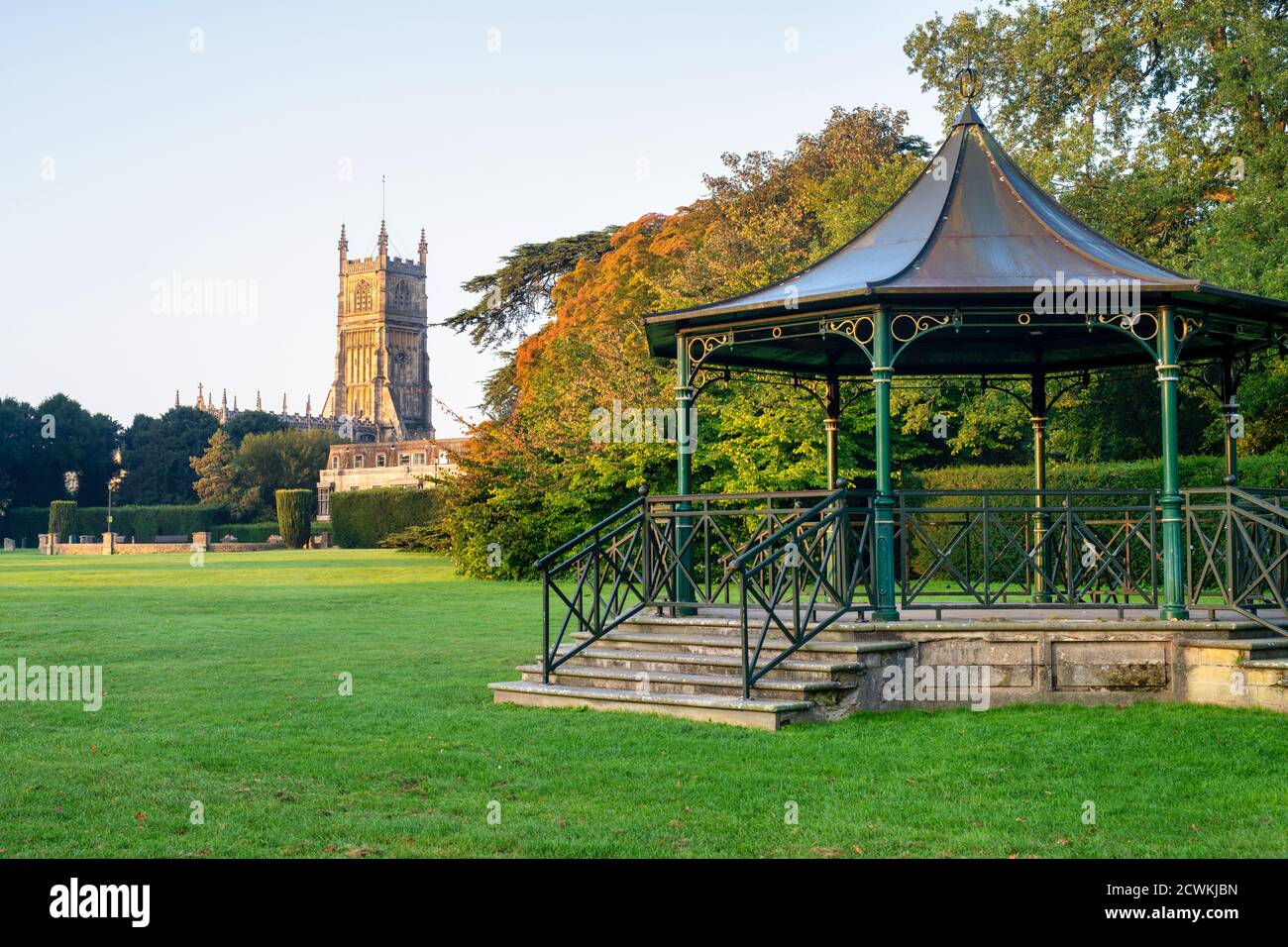 The Church of St. John the Baptist and the bandstand in the abbey grounds at sunrise in autumn. Cirencester, Cotswolds, Gloucestershire, England Stock Photo