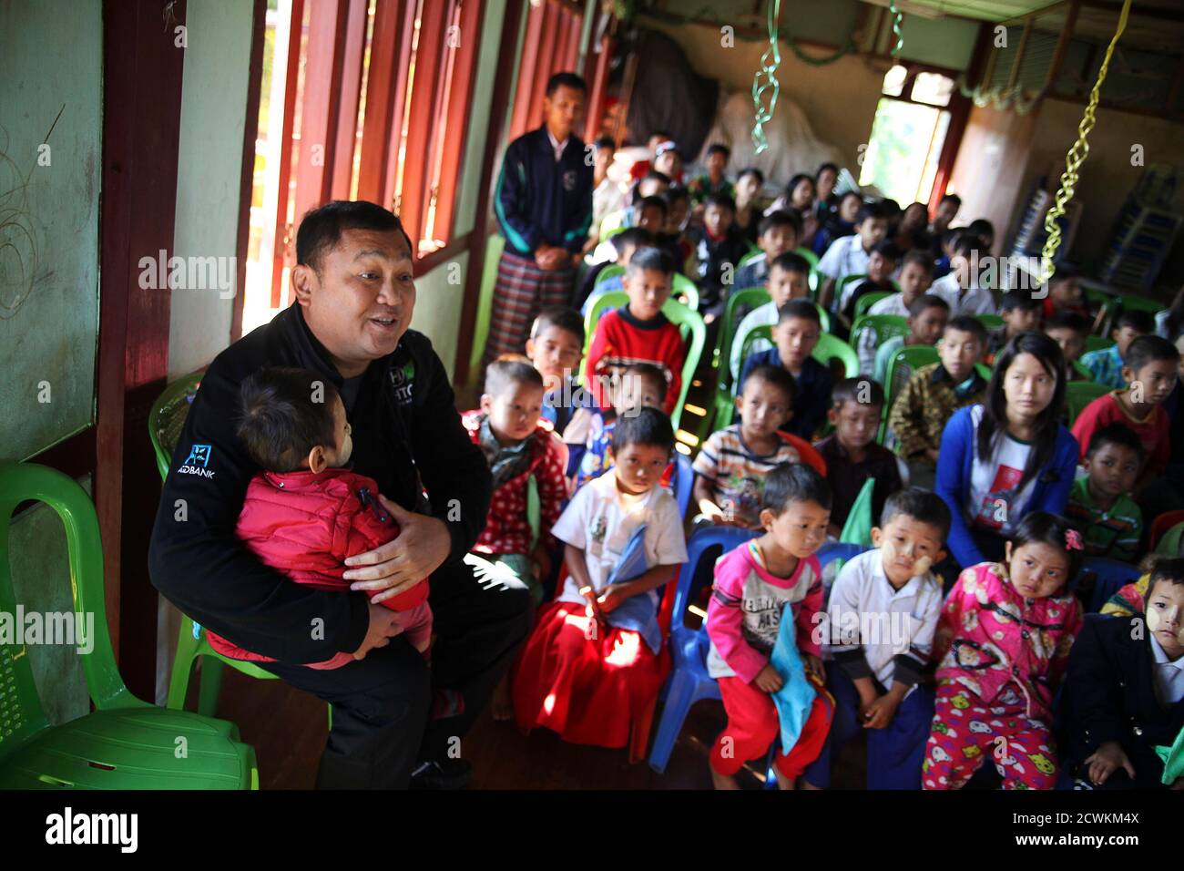 Myanmar tycoon Tay Za holds a child at a school supported by his Htoo Foundation in Myitkyina, Kachin State December 13, 2013. Picture taken December 13, 2013.  REUTERS/Jared Ferrie (MYANMAR - Tags: BUSINESS POLITICS SOCIETY) Stock Photo