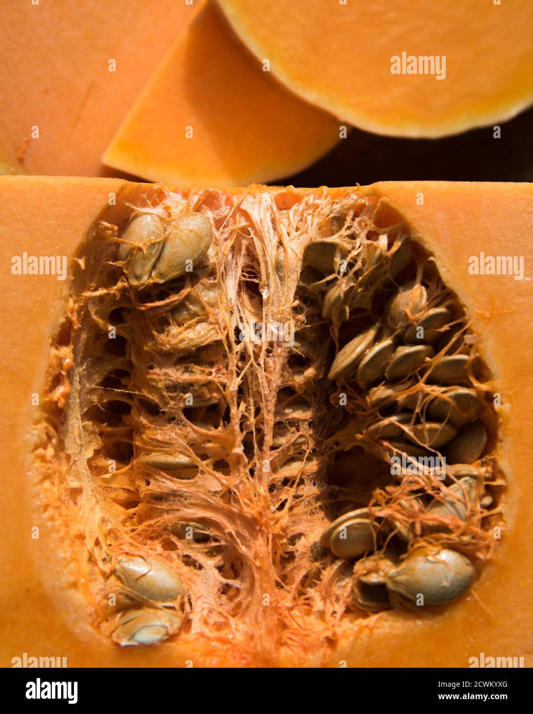 Half of the fresh pumpkin and slices of pumpkin on the table ...
