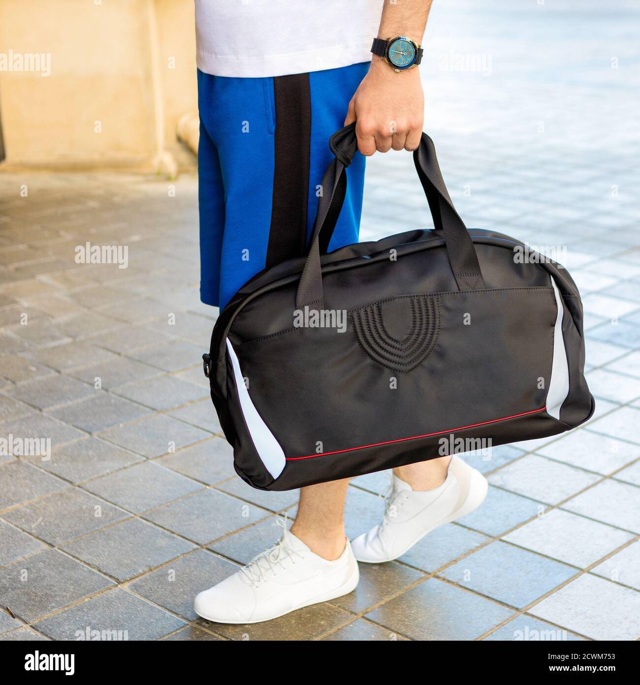 Young man holding a black sport bag close up Stock Photo