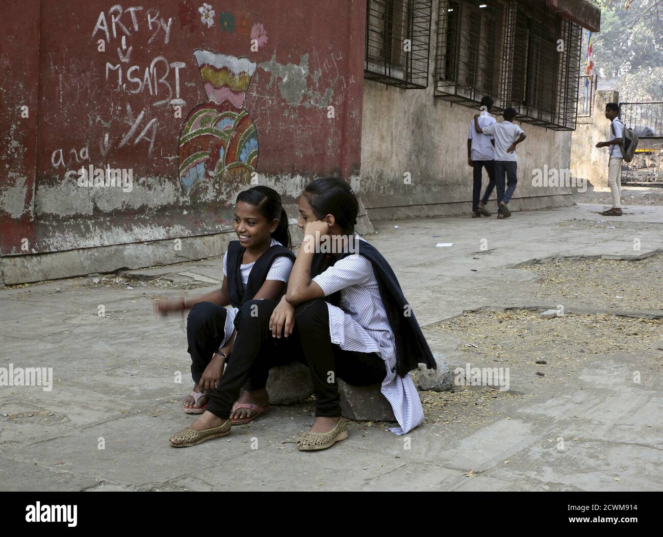 Female students sit in the playground of Shahaji Nagar Municipal Hindi School at Cheeta Camp area in Mumbai, February 24, 2015. As India grapples to stem rising violence against women, activists say classes like these - which confront traditional gender roles and challenge sexism amongst the youth - are key to changing attitudes and curbing widespread gender abuse. Picture taken February 24, 2015. To match Thomson Reuters Foundation Feature story INDIA-GENDER/EDUCATION REUTERS/Nita Bhalla Stock Photo
