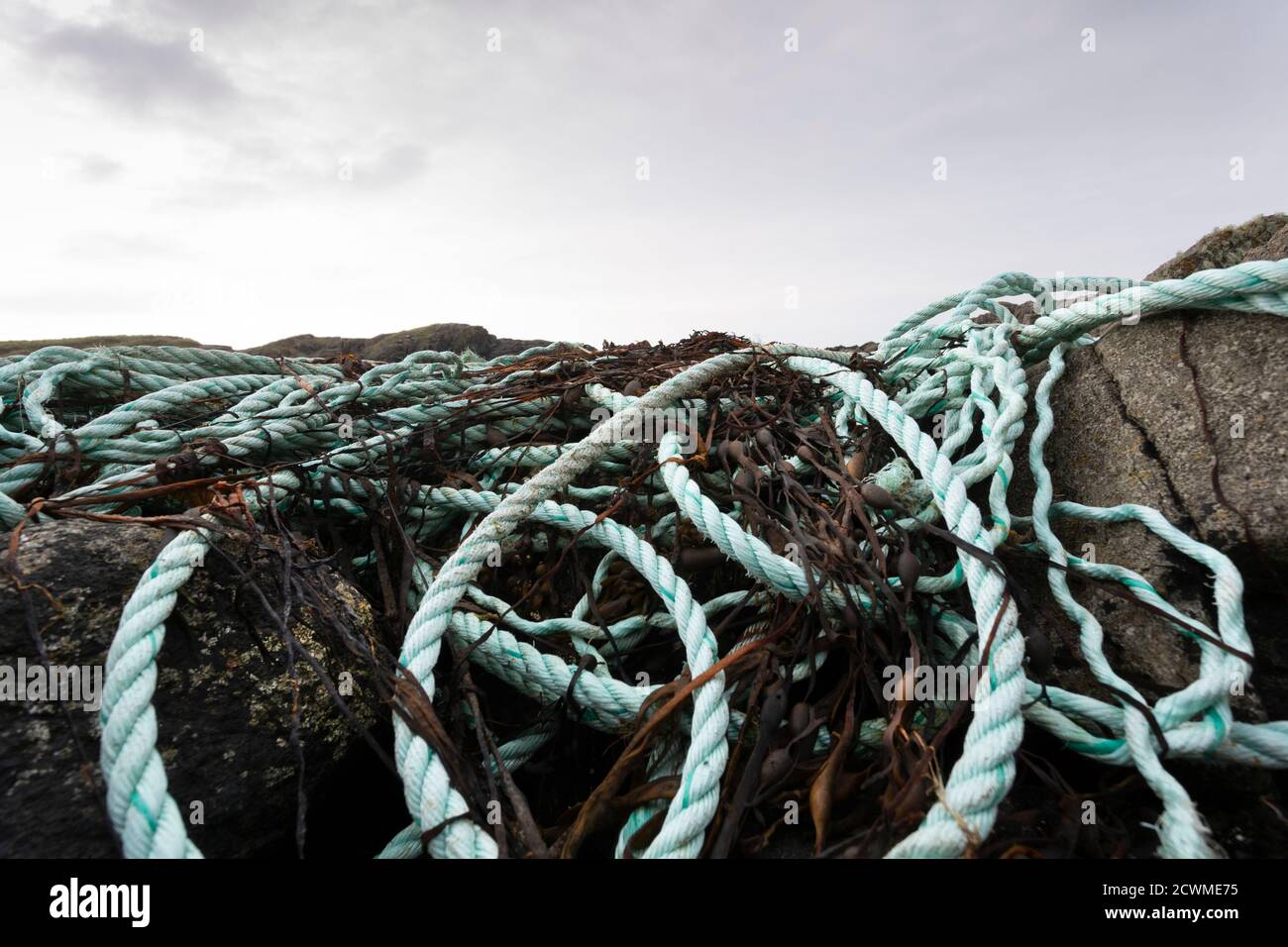 Debris from fishing industry washed up on rocks, nylon and plastic rope and netting is a major problem around all shorelines of the planet Stock Photo