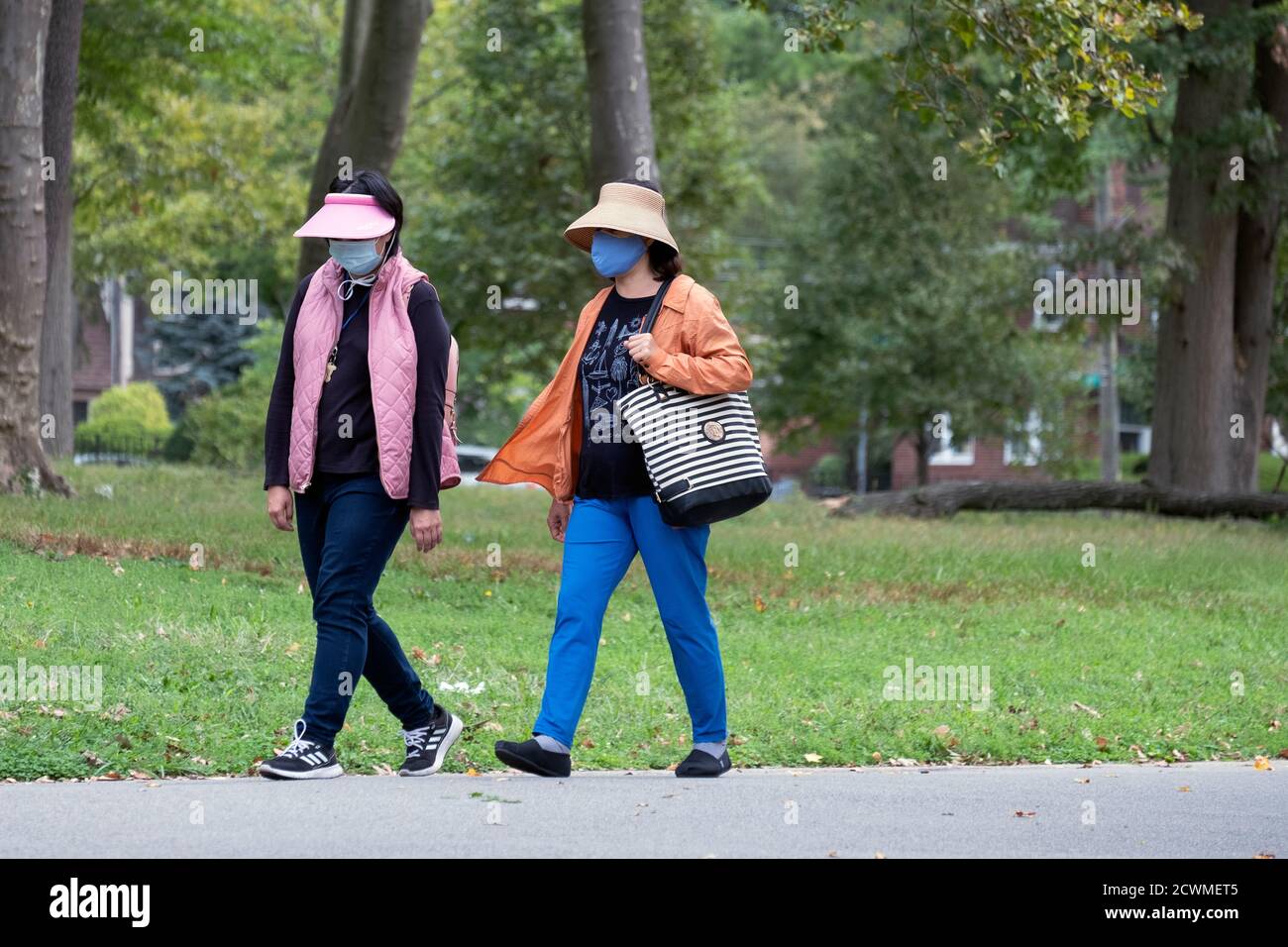 2 middle aged Asian American women out for an exercise walk on a path in a park in Flushing, Queens, New York City. Stock Photo