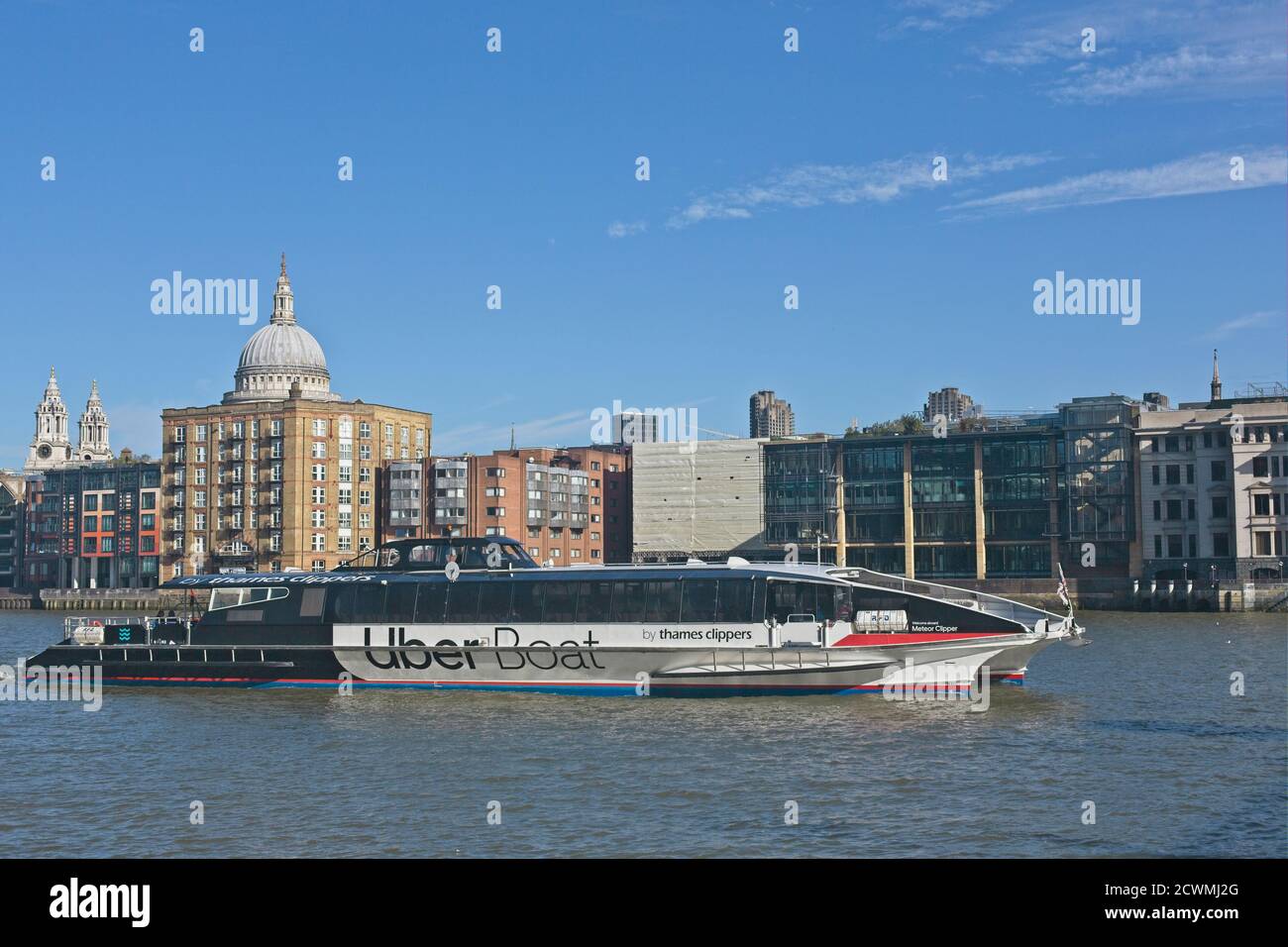 Thames river boat with Uber branding opposite St Paul's Cathedral in central London Stock Photo