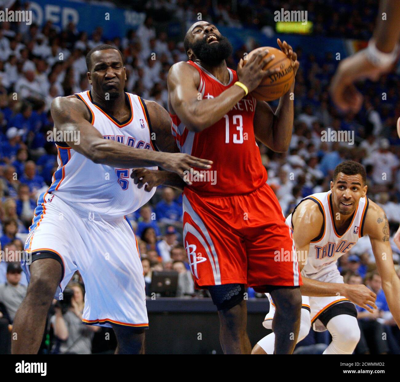 Houston Rockets guard James Harden (C) is fouled by Oklahoma City Thunder  center Kendrick Perkins (L) as Thunder guard Thabo Sefolosha of Switzerland,  (R) looks on in the second half of their