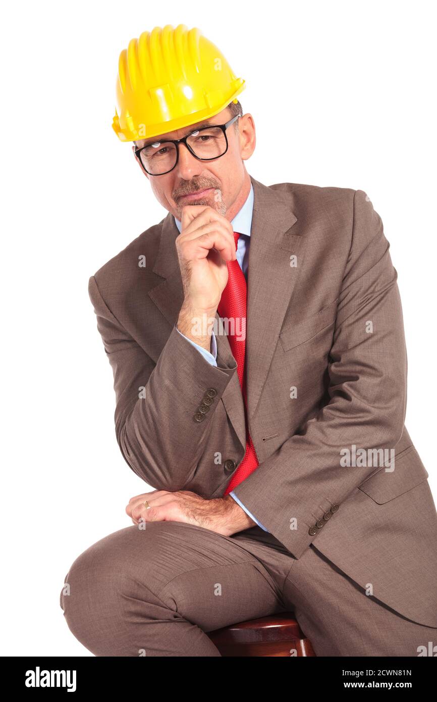 pensive old construcion engineer sitting on chair on white background