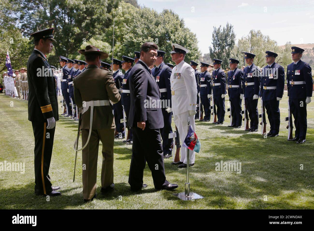 An army officer (2nd L) offers directions to China's President Xi (3rd L) as he inspects an honour guard at Government House in Canberra November 17, 2014. REUTERS/David Gray (AUSTRALIA -