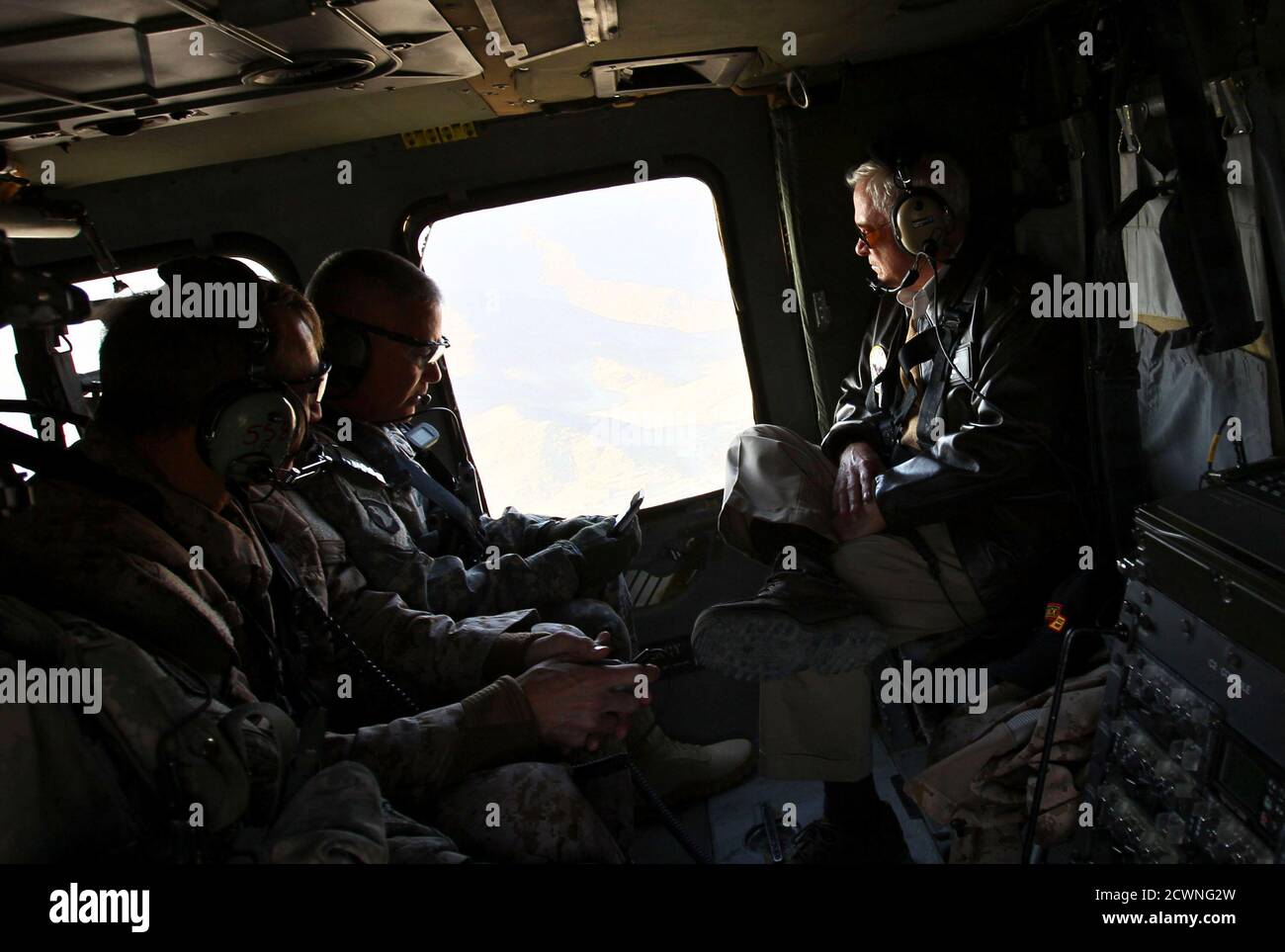 U.S. Secretary of Defense Robert Gates (R) receives a briefing from Major Gen. John Campbell (C) while flying aboard a helicopter over Kunar Province on his way to meet U.S. soldiers in Afghanistan, December 7, 2010. Gates arrived today in Afghanistan for an unannounced visit during a tour of the region this week. The White House is conducting a review of the war in Afghanistan a year after President Barack Obama unveiled a revised strategy to battle Taliban militants and ease violence in one of the world's poorest nations.  REUTERS/Win McNamee/Pool  (AFGHANISTAN - Tags: MILITARY POLITICS) Stock Photo