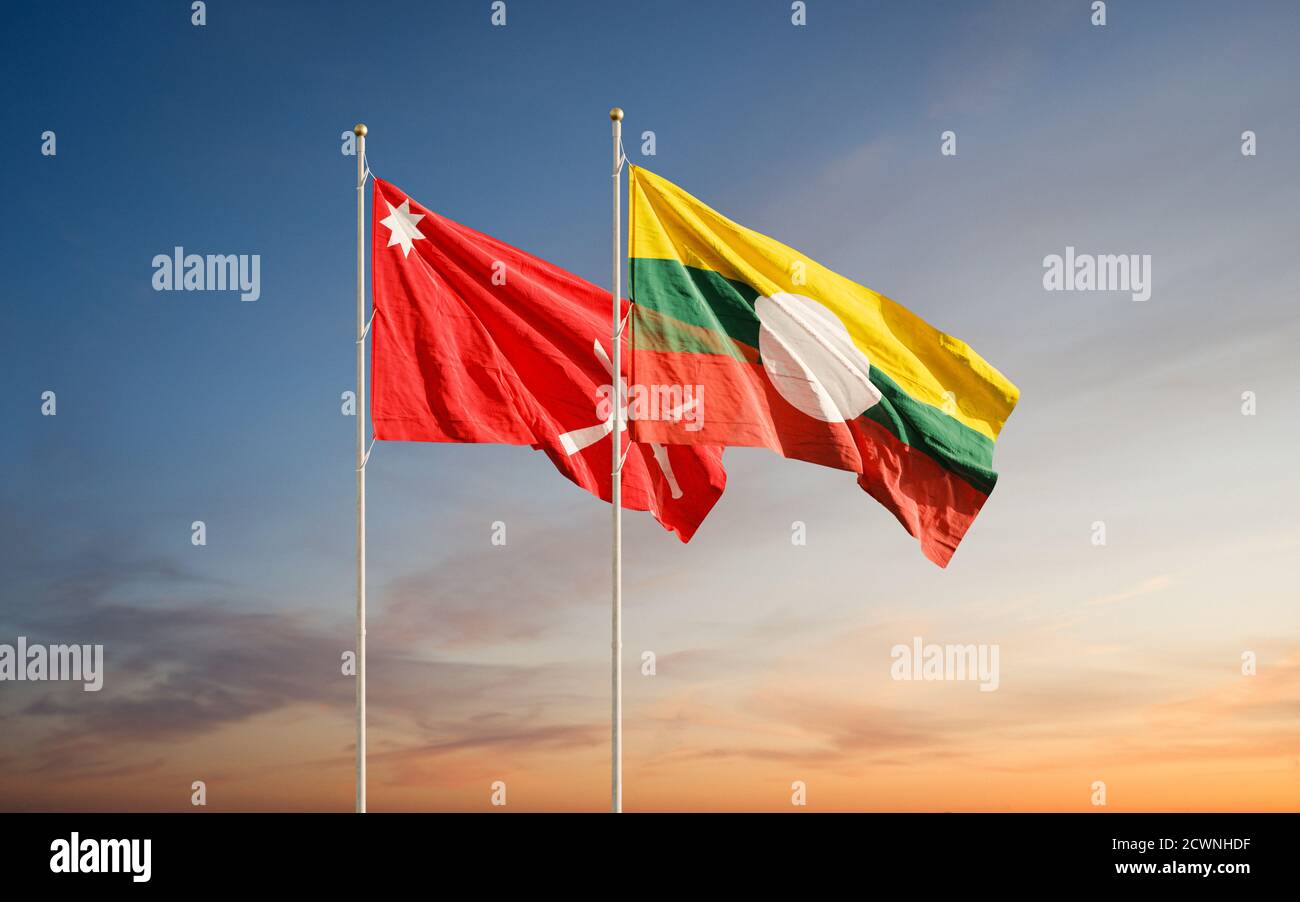 Waving flags of Shan State and Shan State Army South against sunset sky background. Stock Photo