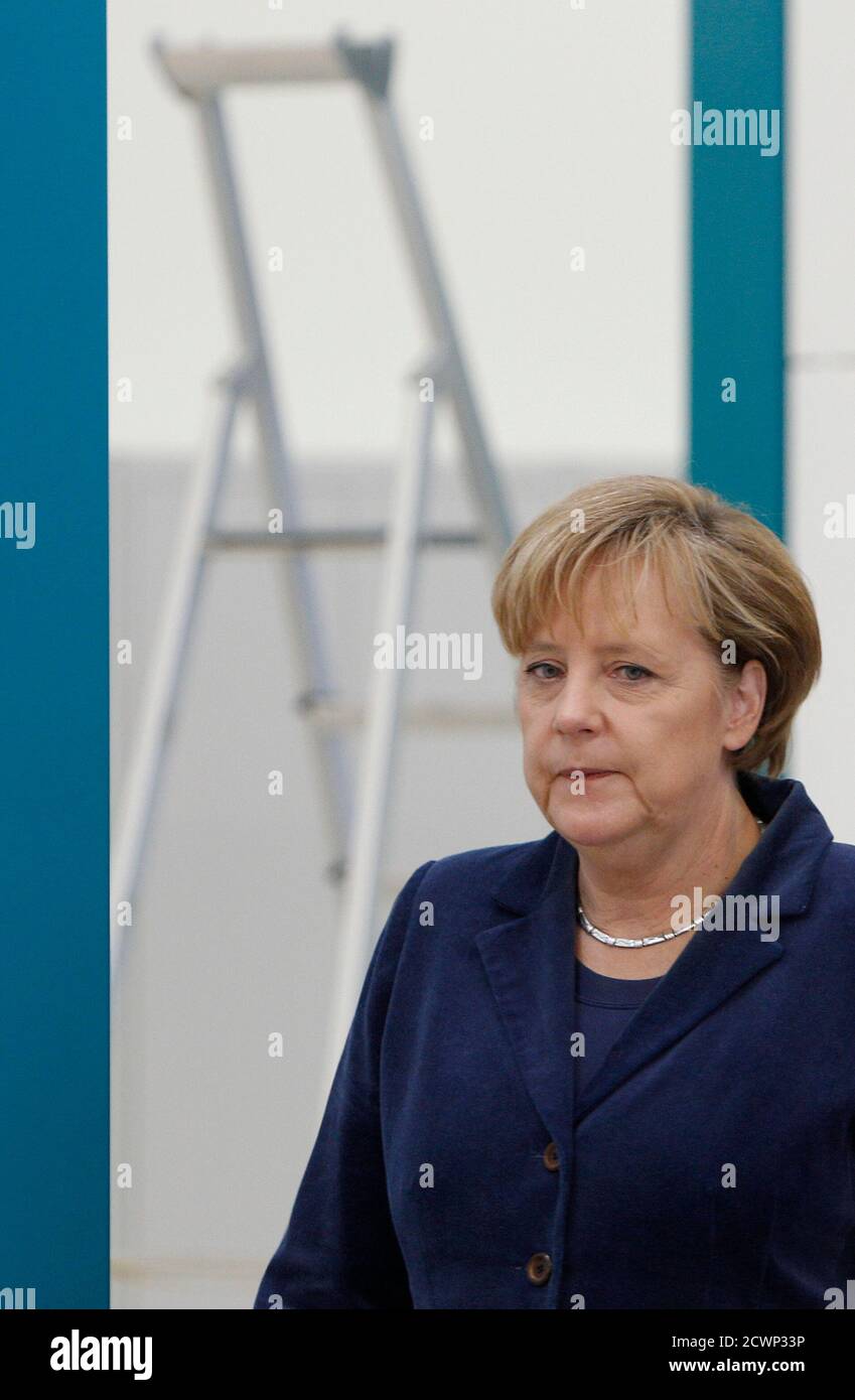 German Chancellor Angela Merkel Walks Past A Stepladder During Her Visit In The Manz Automation Ag