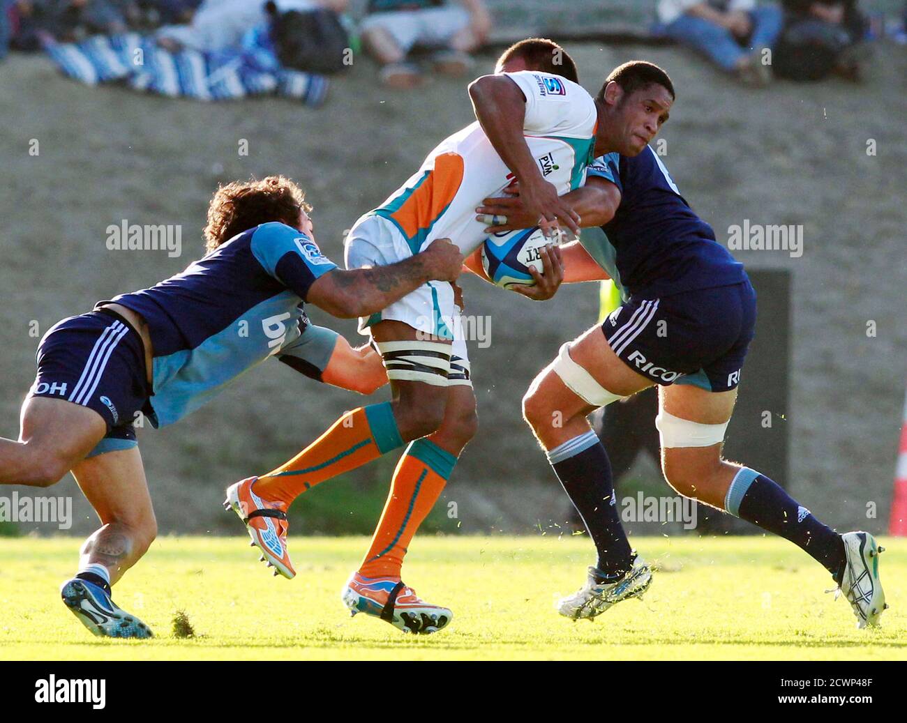 Devon Raubenheimer (C) of the South African Cheetahs is tackled by Rene Ranger (L) and Chris Lowery of New Zealand's Auckland Blues during their Super 15 rugby match in Whangarei April 2, 2011. The Blues won the match 29-22. REUTERS/Nigel Marple (NEW ZEALAND - Tags: SPORT RUGBY) Stock Photo