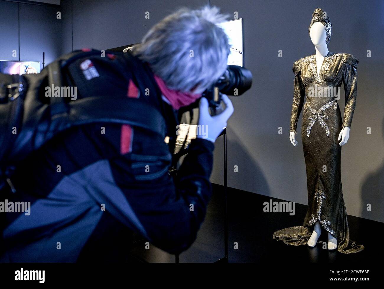 30 September 2020, Berlin: A visitor photographs the evening gown made of silver lamé from the film Lili Marleen by director Werner Fassbender for the actress Hanna Schygulla in the exhibition 'Hautnah. The Film Costumes of Barbara Baum' at the Deutsche Kinemathek - Museum für Film und Fernsehen. From 01.10. 2020 to 03.05.2021 over 40 original film costumes from five decades of costume design will be shown. Photo: Britta Pedersen/dpa-Zentralbild/dpa - ATTENTION: Only for editorial use in connection with current reporting and only with full mention of the above credit Stock Photo