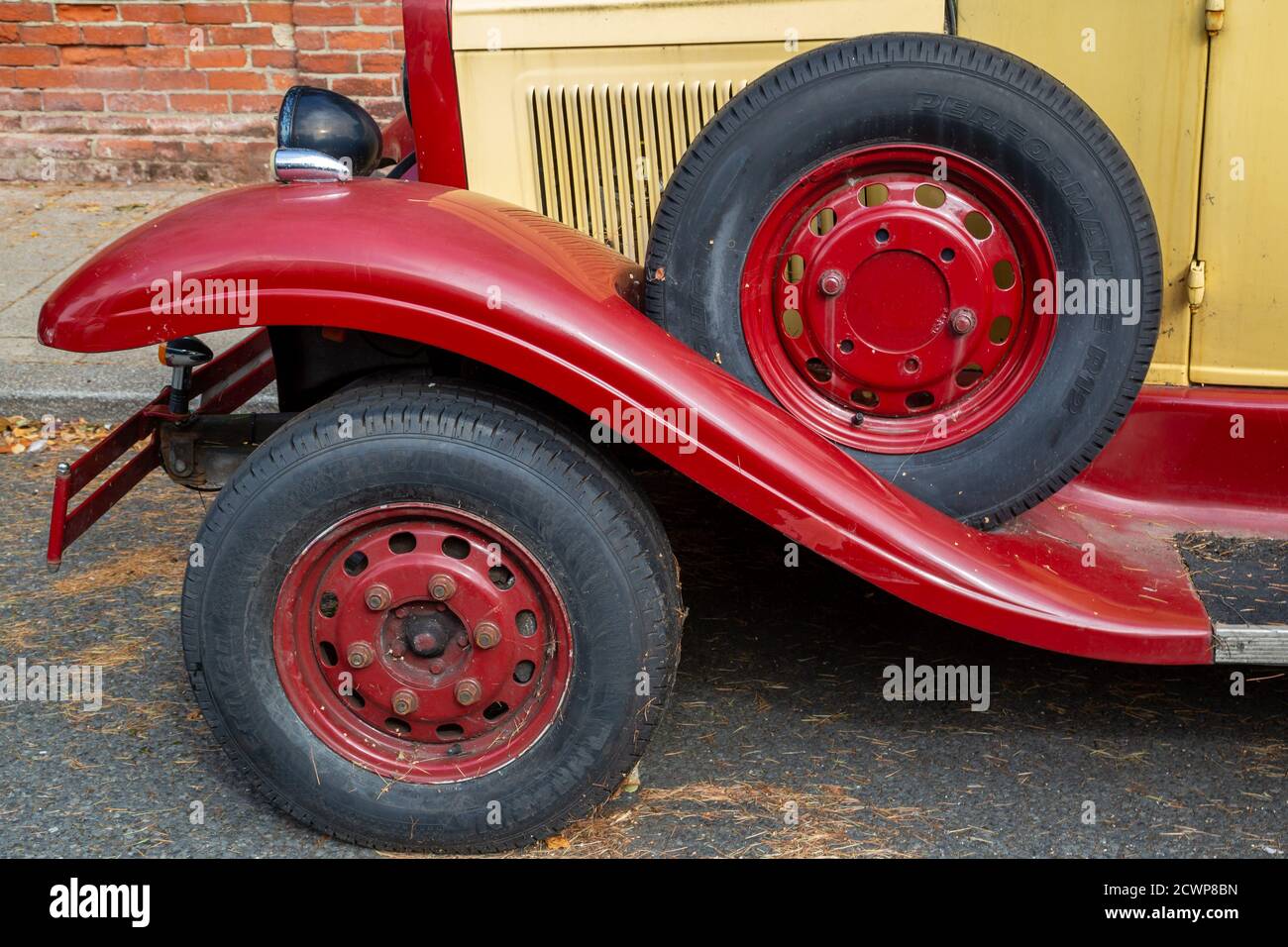 The front wheels of a vintage motor car with a spare tyre above Stock Photo