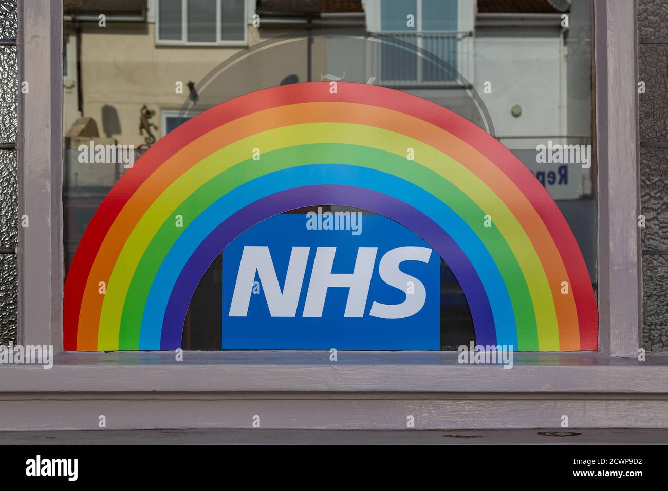 A rainbow and NHS sign in the window of a shop, showing support for the