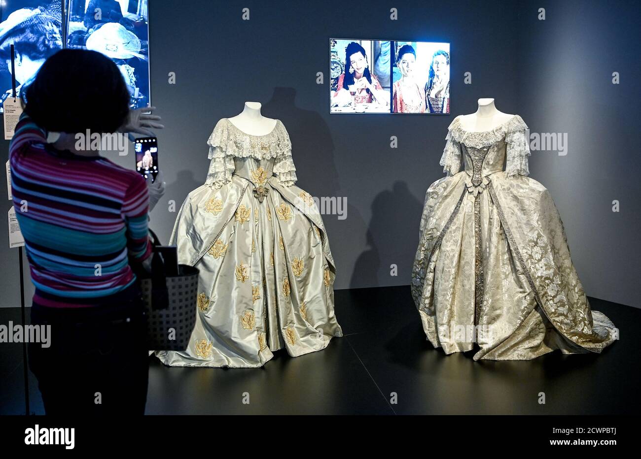Berlin, Germany. 30th Sep, 2020. A woman photographs clothes from the film 'Catherine the Great' by Marvin J. Chomsky, and John Goldsmith in the exhibition 'Hautnah. The Film Costumes of Barbara Baum' at the Deutsche Kinemathek - Museum für Film und Fernsehen. From 01.10. 2020 to 03.05.2021 over 40 original film costumes from five decades of costume design will be shown. Credit: Britta Pedersen/dpa-Zentralbild/dpa - ATTENTION: Only for editorial use in connection with current reporting and only with full mention of the above credit/dpa/Alamy Live News Stock Photo