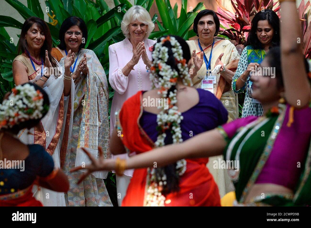 Britain's Camilla (C), Duchess of Cornwall, applauds a performance by  students during a visit to the Asha Sadan children's home in Mumbai  November 9, 2013. Prince Charles and his wife Camilla are