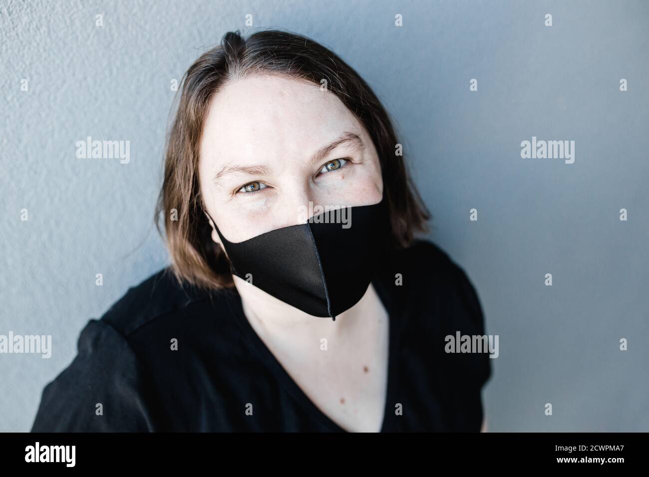 Caucasian woman wearing a black mask during the COVID-19 Coronavirus pandemic Stock Photo