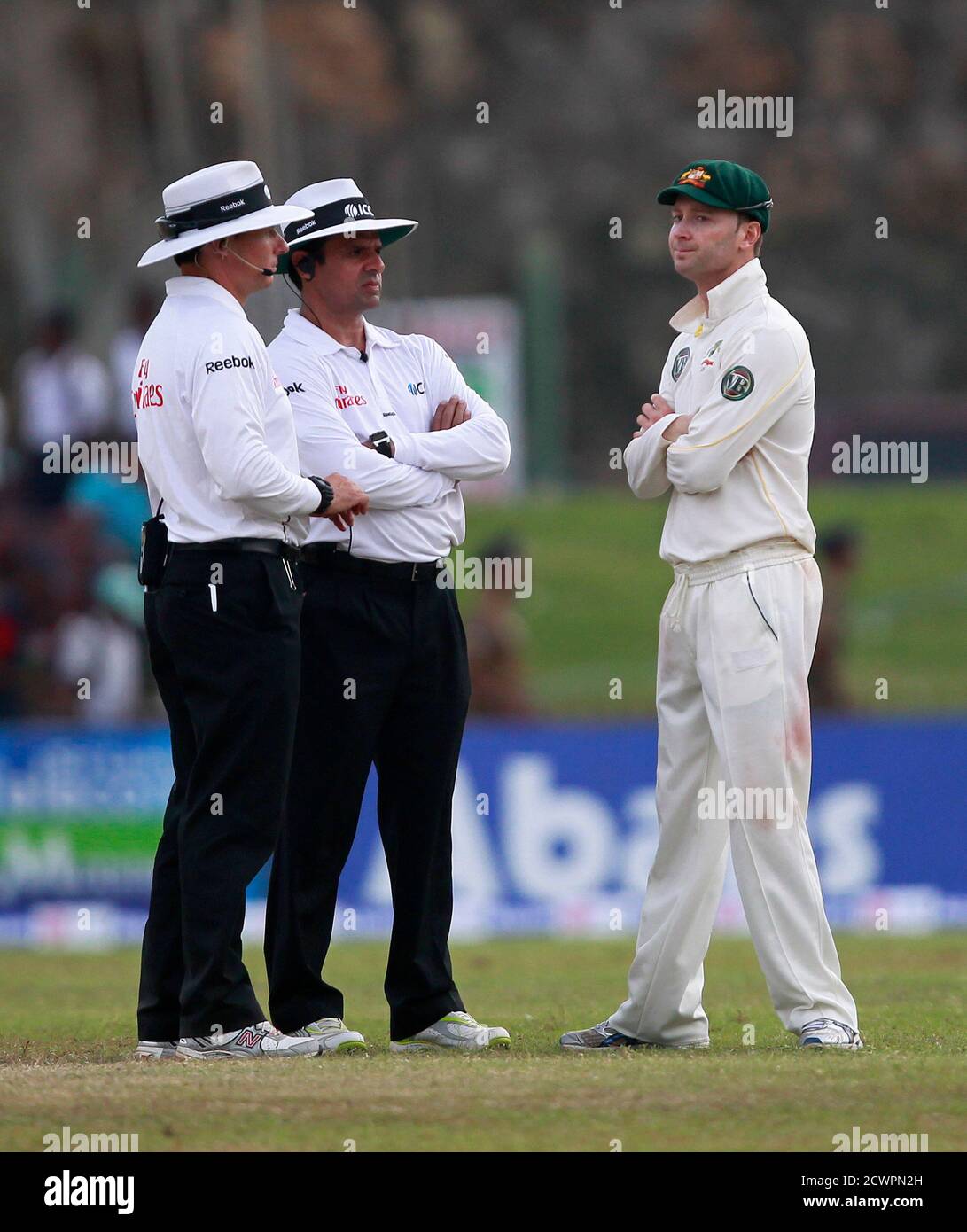 Australia's captain Michael Clarke (R) talks with umpires Aleem Dar and Richard Kettleborough as the players leave the field due to bad light during the third day of their first test cricket match in Galle September 2, 2011. REUTERS/Dinuka Liyanawatte (SRI LANKA - Tags: SPORT CRICKET) Stock Photo