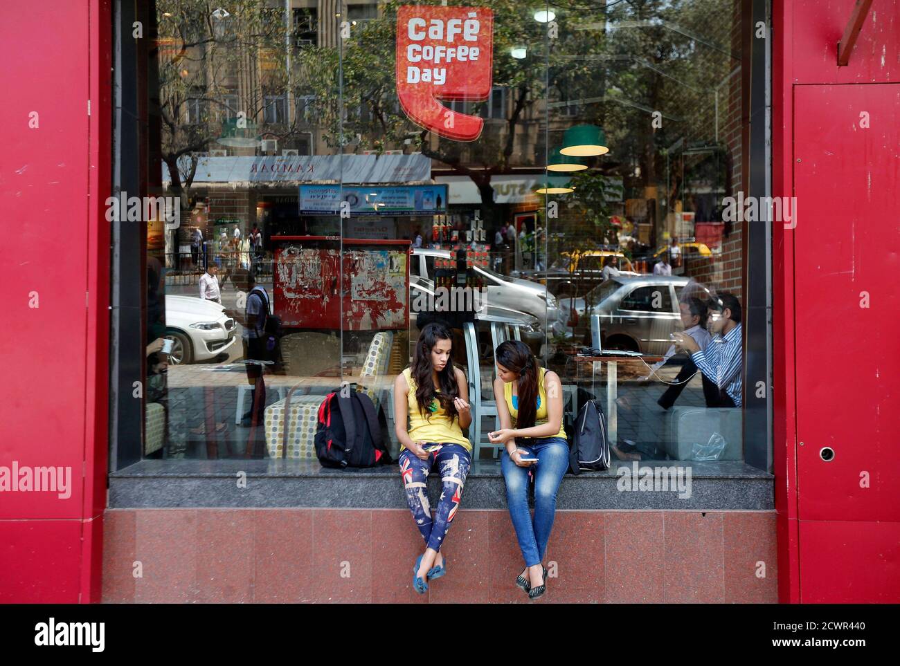 Girls sit at the window of a Cafe Coffee Day outlet in Mumbai ...