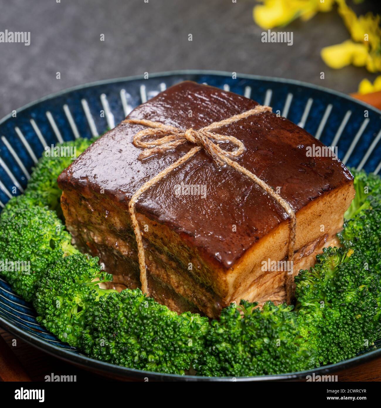 Dong Po Rou (Dongpo pork meat) in a beautiful plate with green vegetable, traditional festive food for Chinese new year cuisine meal, close up. Stock Photo