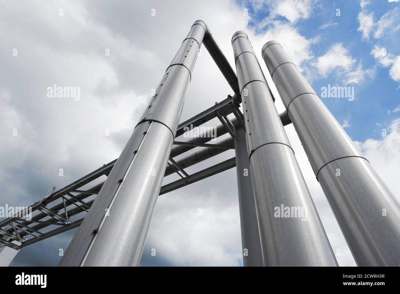 shiny industrial pipes under cloudy sky Stock Photo