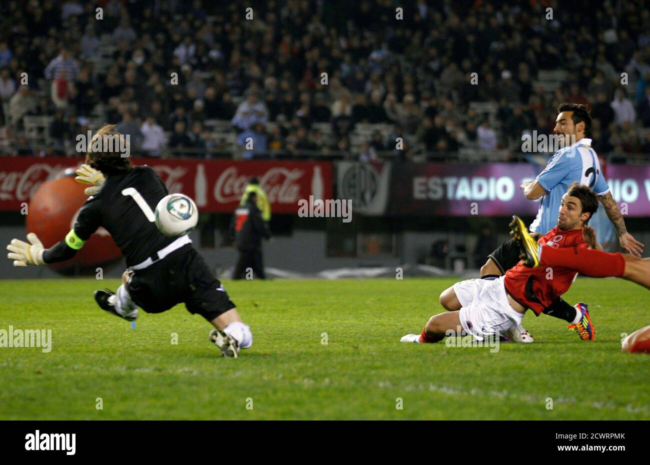 Ezequiel Lavezzi (R, top) of Argentina scores under pressure from Elis  Bakaj (R) and goalkeeper Arjan Beqaj (L) of Albania during their  international friendly soccer match in Buenos Aires June 20, 2011.