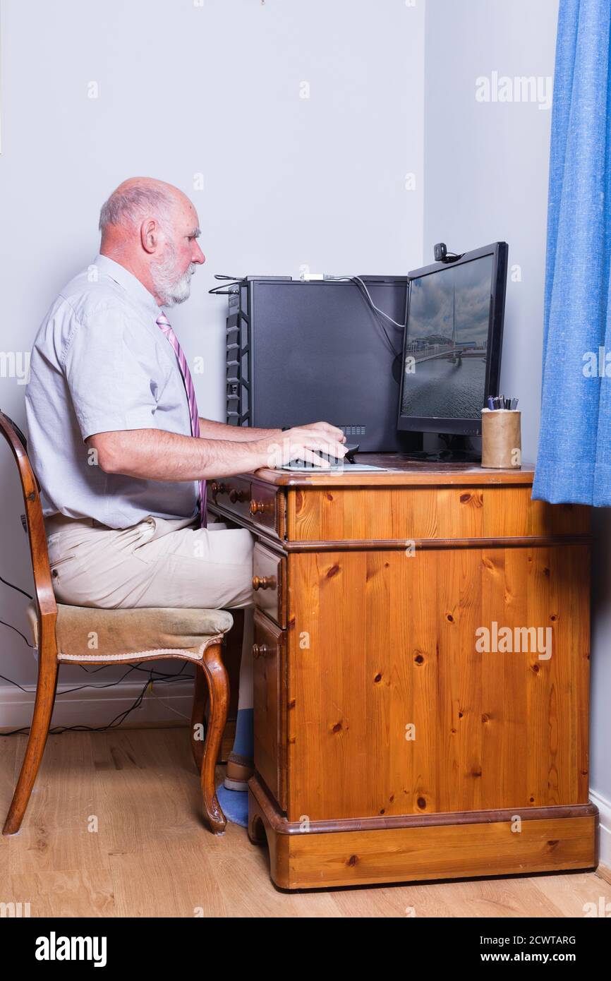Gentleman of 70 working on his desktop computer. Stock Photo