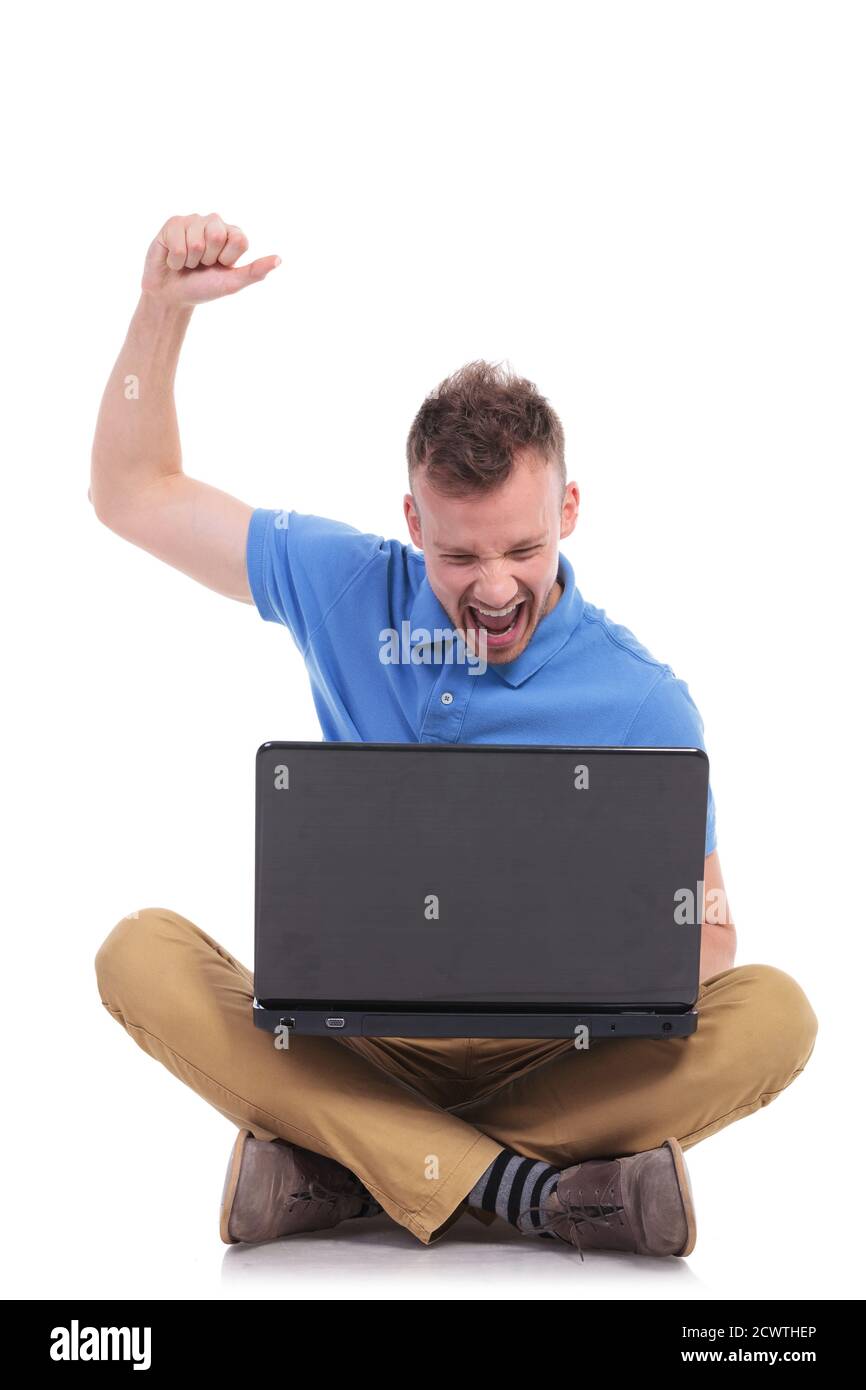 casual young man sitting on the floor with his legs crossed and ...