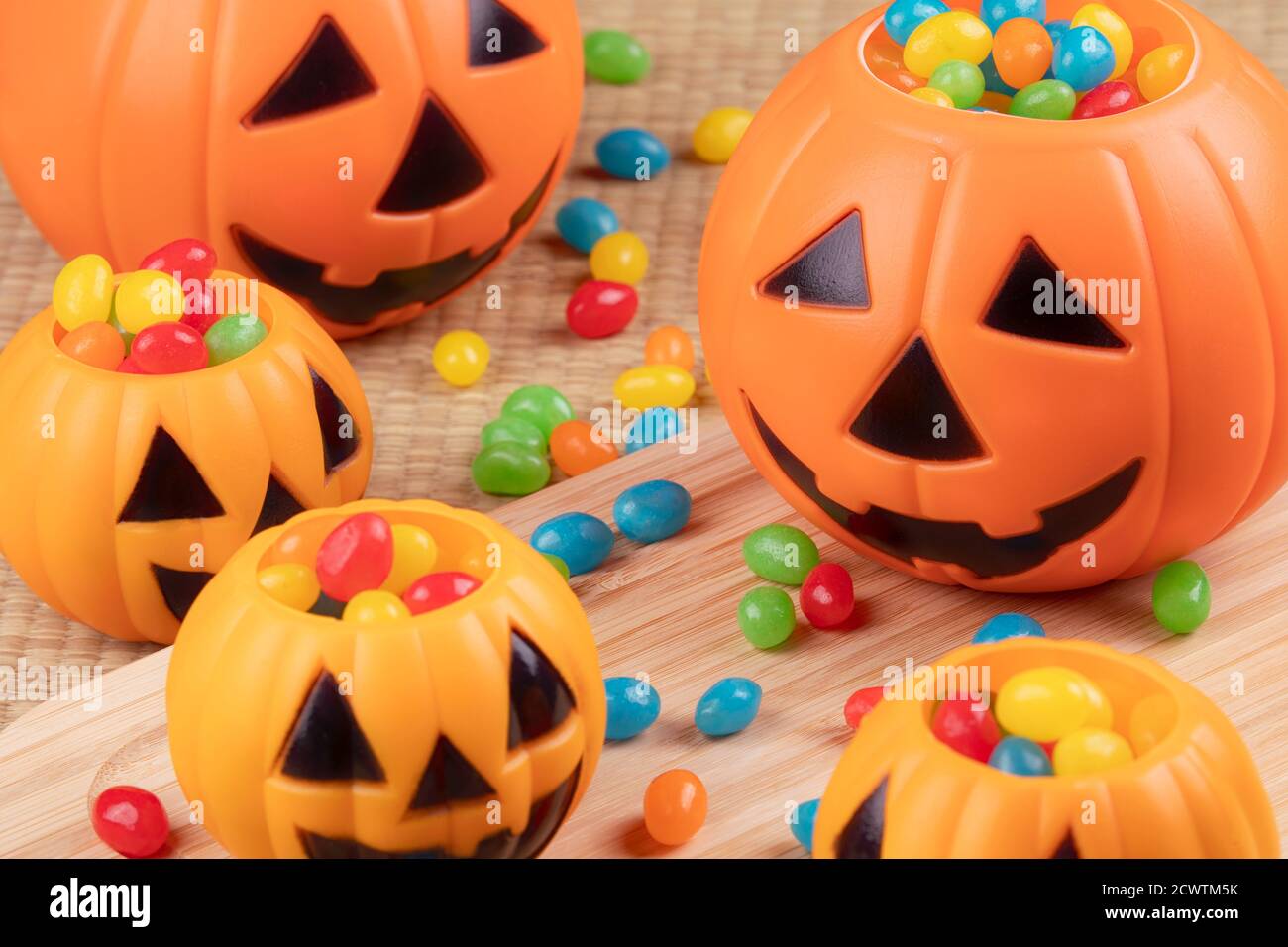 Halloween decorations using plastic pumkins and jelly beans on a wooden background Stock Photo