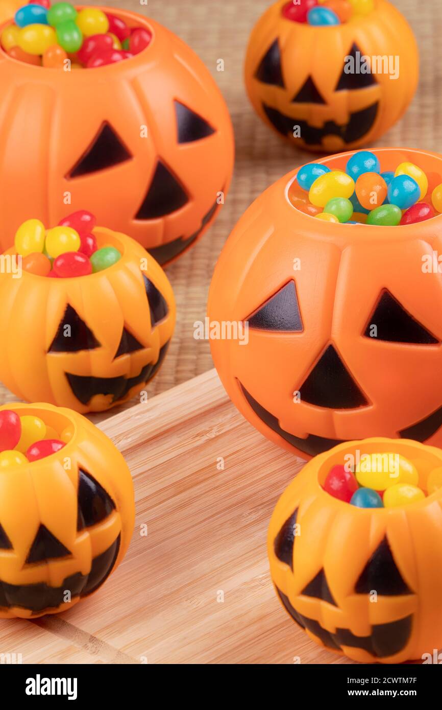 Halloween decorations using plastic pumkins and jelly beans on a wooden background Stock Photo