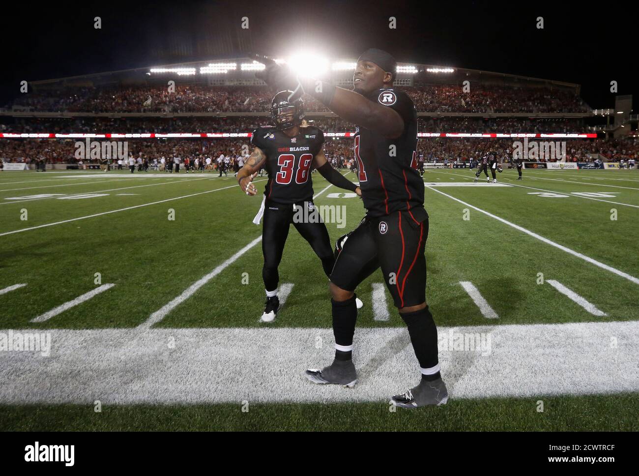 Ottawa Redblacks' Jasper Simmons (front) and James Green celebrate after defeating the Toronto Argonauts in their CFL football game in Ottawa July 18, 2014. REUTERS/Chris Wattie (CANADA - Tags: SPORT FOOTBALL) Stock Photo