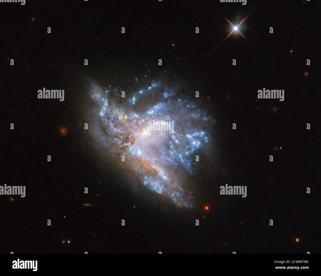 Hubble’s Dazzling Display of Two Colliding Galaxies Located in the constellation of Hercules, about 230 million light-years away, NGC 6052 is a pair of colliding galaxies. They were first discovered in 1784 by William Herschel and were originally classified as a single irregular galaxy because of their odd shape. However, we now know that NGC 6052 actually consists of two galaxies that are in the process of colliding. This particular image of NGC 6052 was taken using the Wide Field Camera 3 on the NASA/ESA Hubble Space Telescope.  A long time ago gravity drew the two galaxies together into the Stock Photo