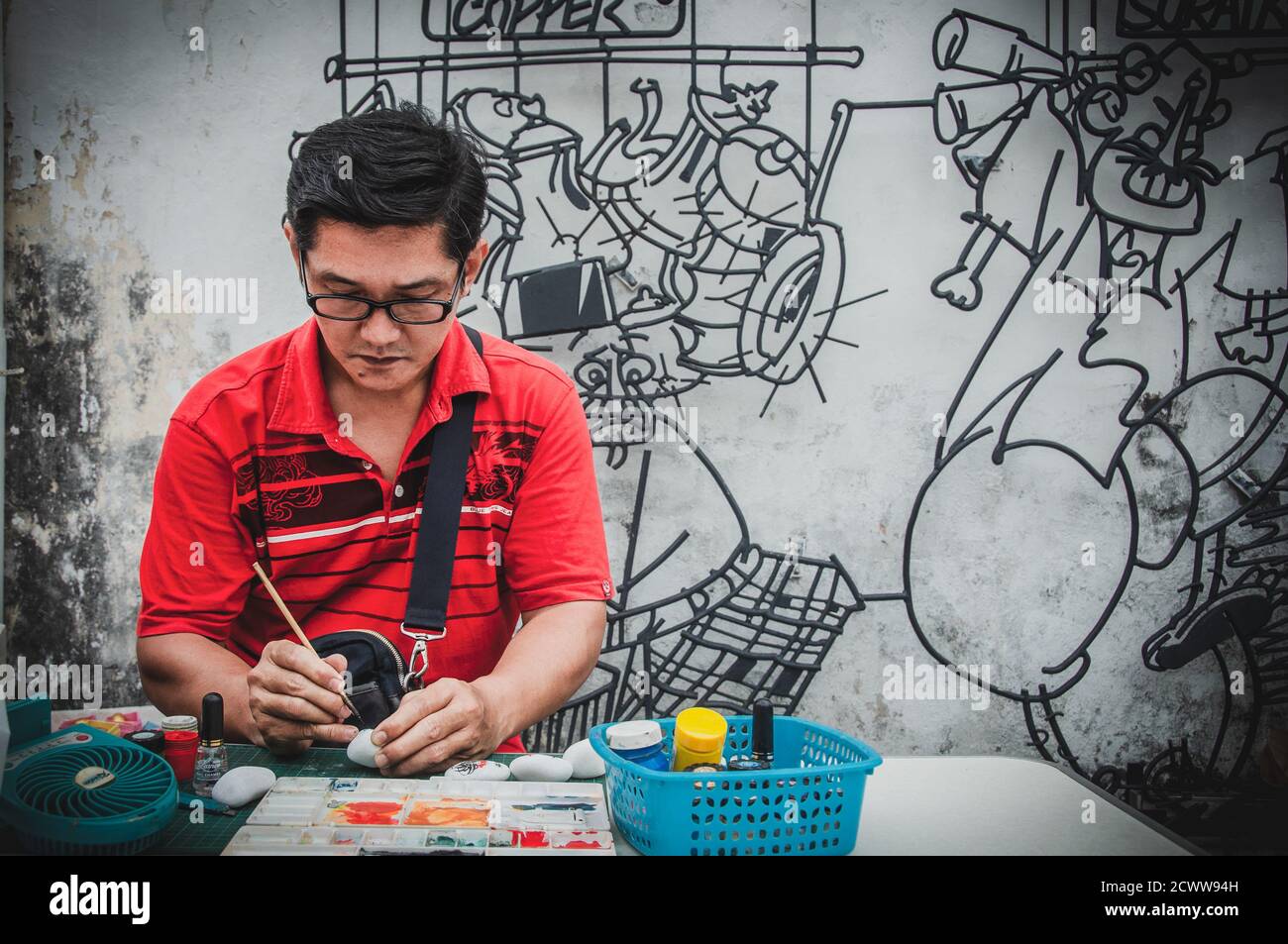 Young Asian man creating an artwork on the street Stock Photo