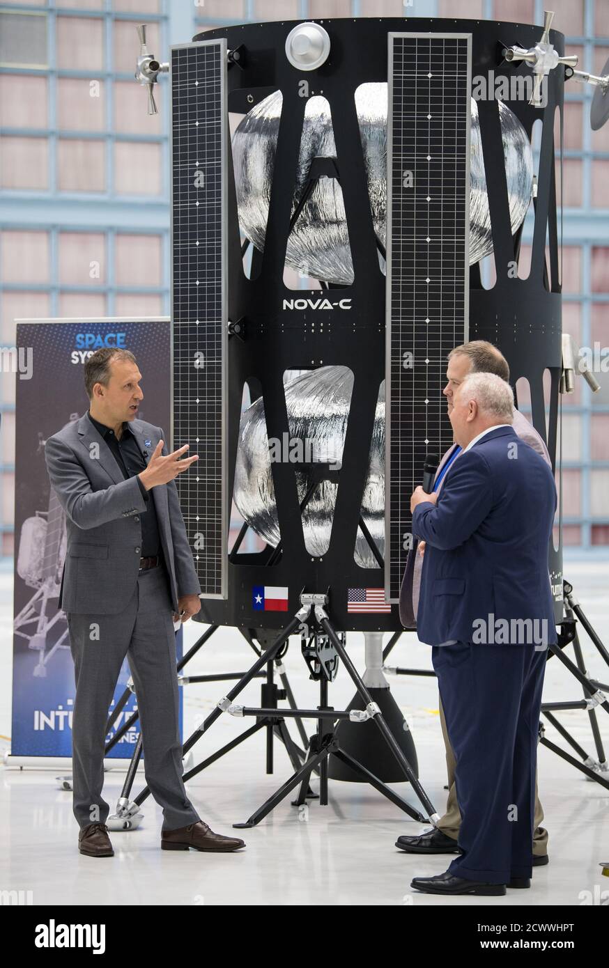 Commercial Lunar Payload Services Announcement NASA Associate Administrator, Science Mission Directorate, Thomas Zurbuchen, left, speaks to, Chairman of the Board of Intuitive Machines, Kam Ghaffarian, right, and VP of Research and Development of Intuitive Machines, Tim Crain, second from right, about their lunar lander, Friday, May 31, 2019, at Goddard Space Flight Center in Md. Astrobotic, Intuitive Machines, and Orbit Beyond have been selected to provide the first lunar landers for the Artemis program's lunar surface exploration. ' Stock Photo