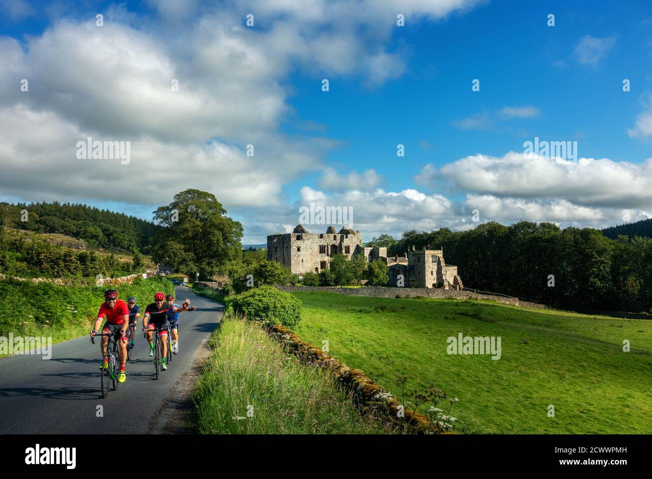 Men socialising on road bikes while cycling past Barden Tower in the