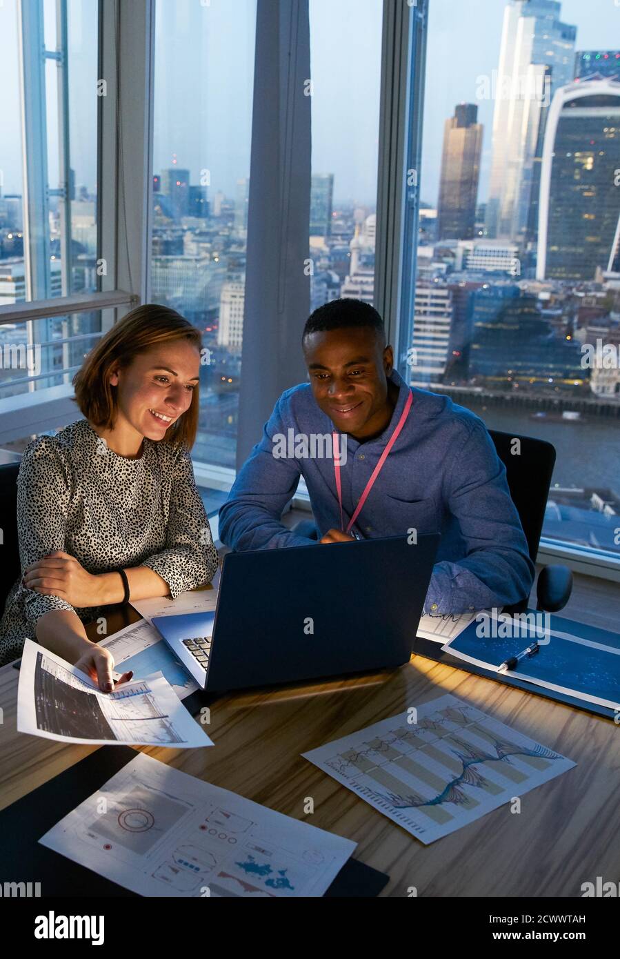 Business people working at laptop in highrise office, London, UK Stock Photo